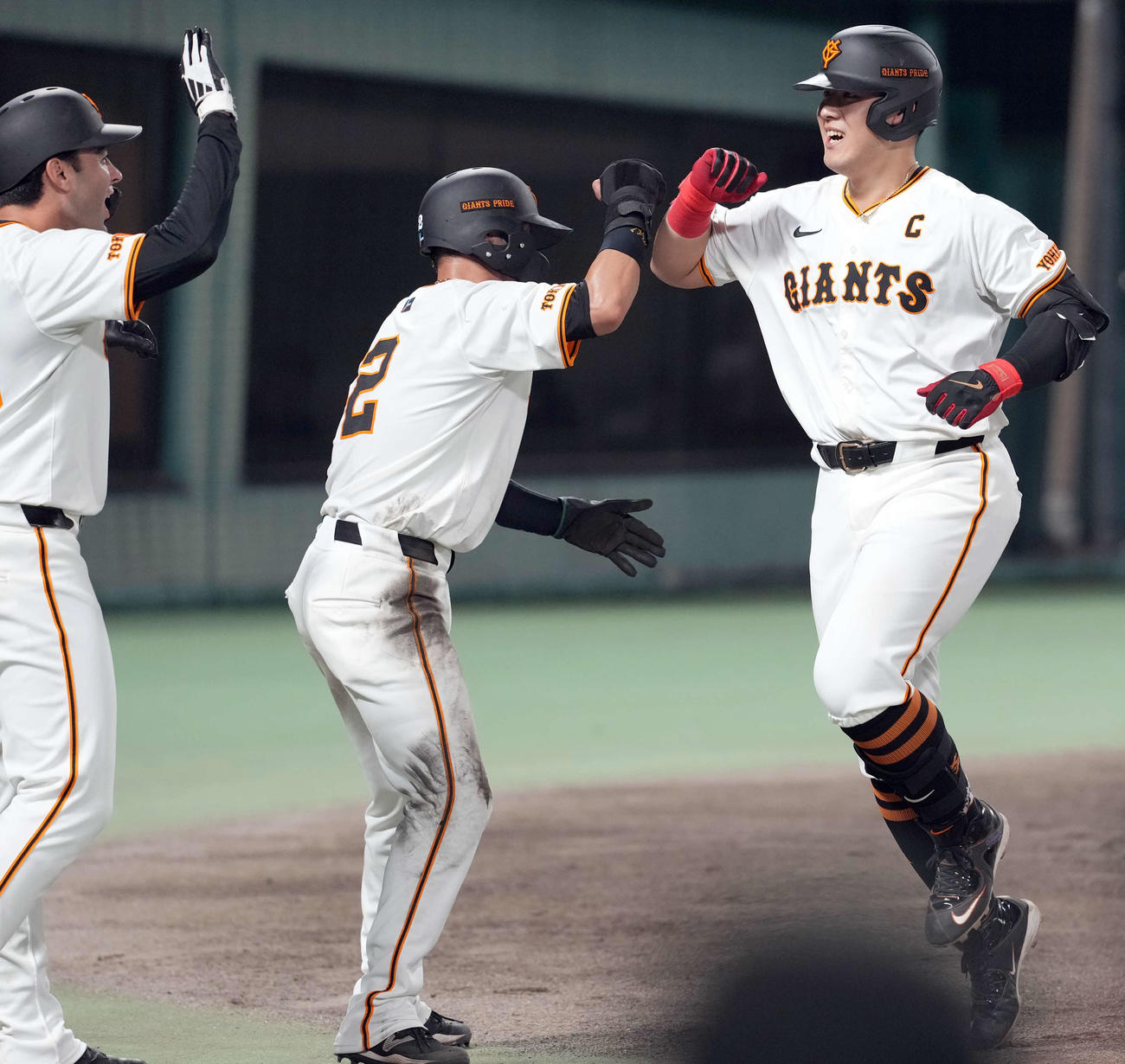 巨人対ヤクルト　5回裏巨人2死一、三塁、右越えに3点本塁打を放ち笑顔を見せる岡本和（右）。左からモンテス、吉川（撮影・たえ見朱実）