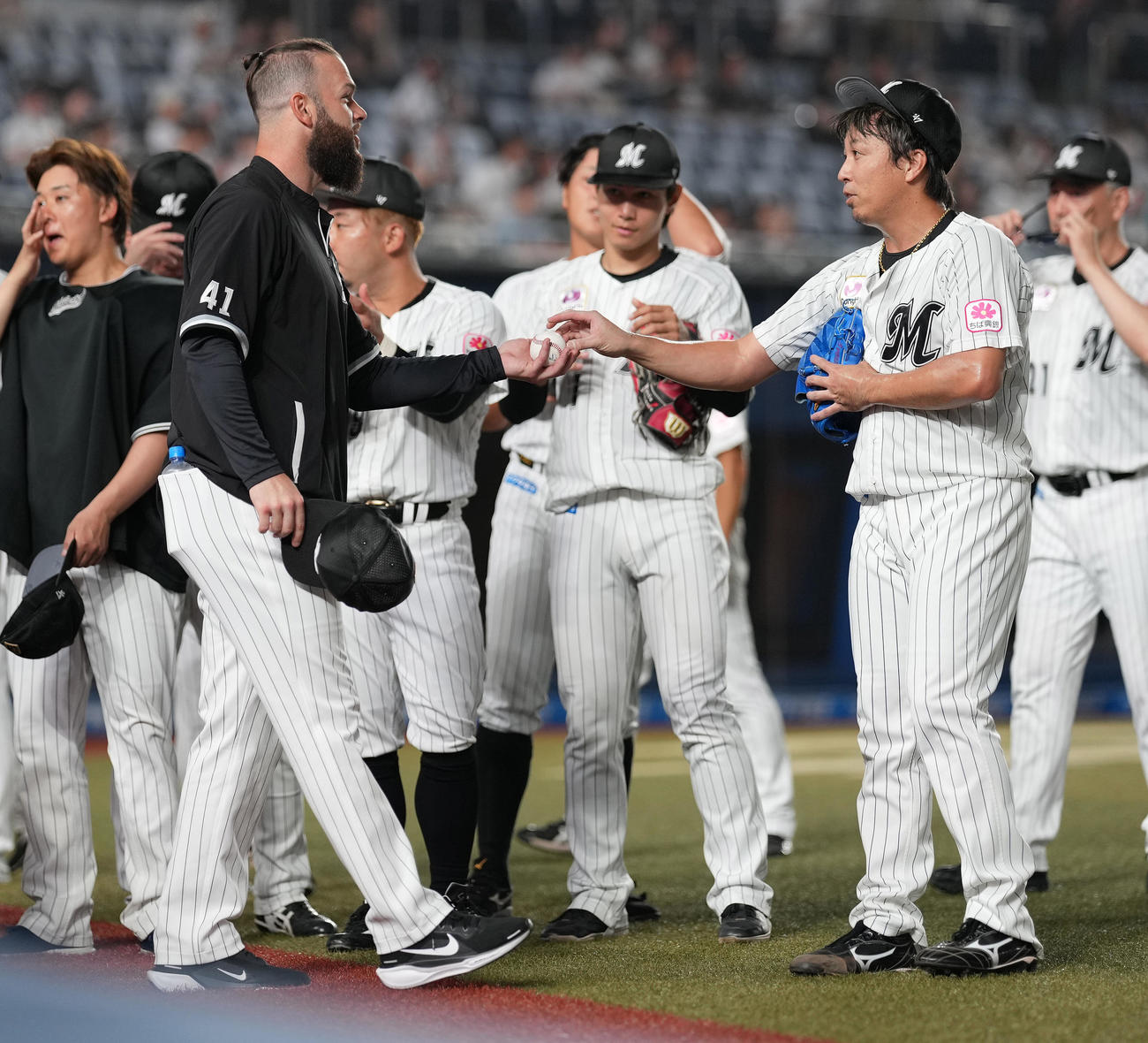 ロッテ対楽天　来日初勝利のロッテ・カイケル（左手前）は益田（右手前）からウイニングボールを受け取る（撮影・鈴木みどり）