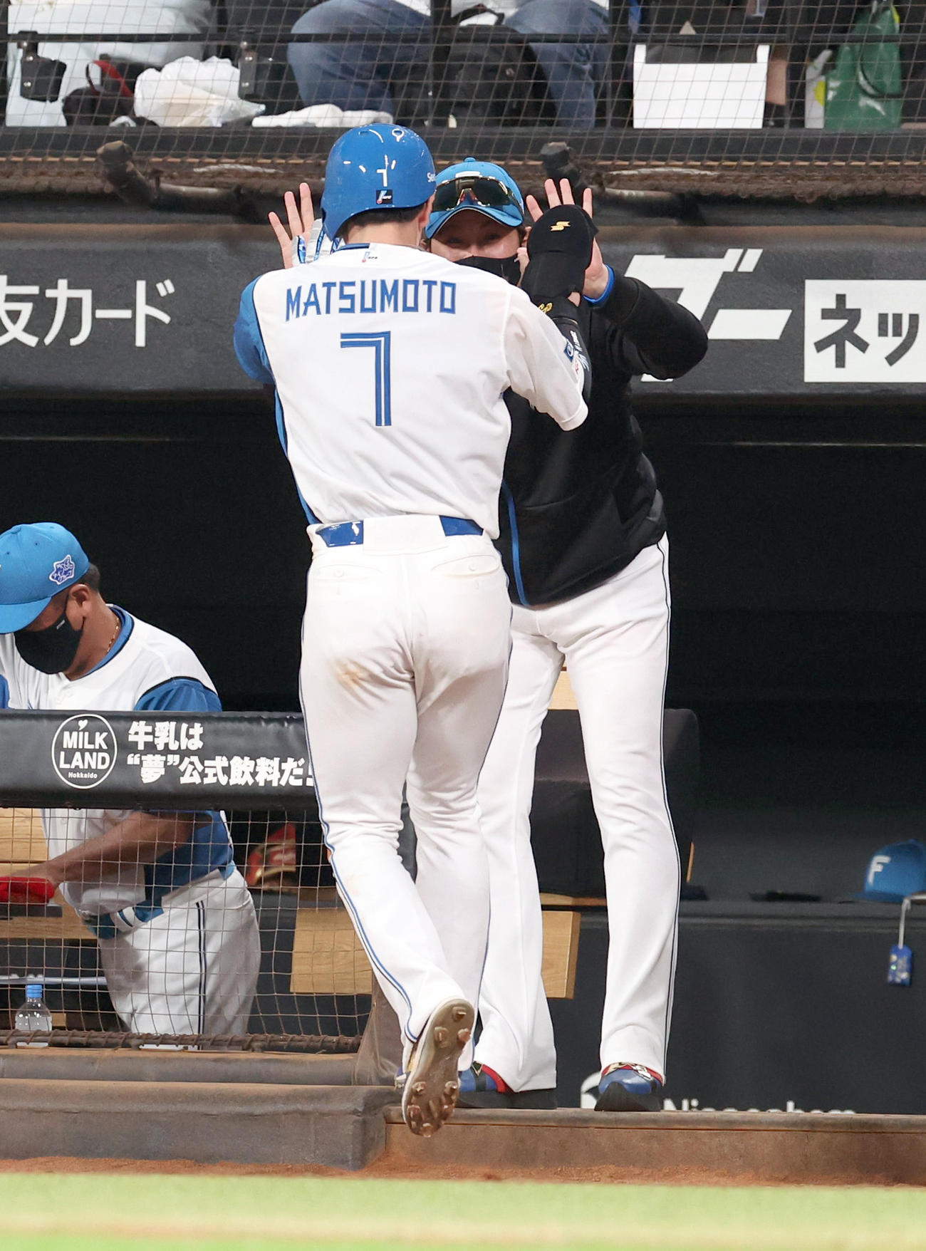 日本ハム対オリックス　6回裏日本ハム1死二、三塁、浅間の中前2点適時打で生還した松本剛（左手前）を出迎える新庄監督（撮影・佐藤翔太）
