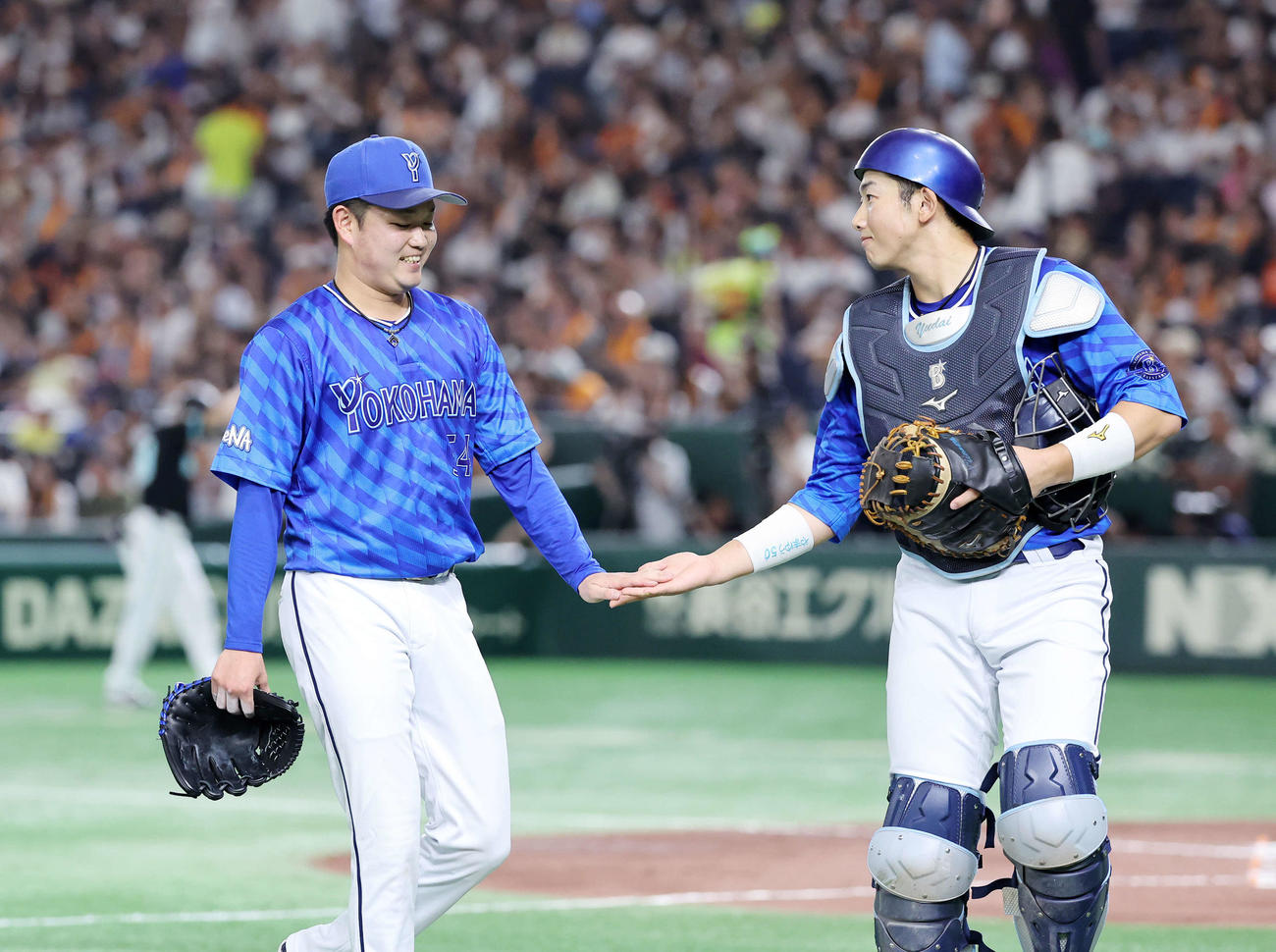 巨人対DeNA 2回裏、巨人の攻撃を抑え笑顔でタッチするDeNA石田裕（左）と山本（撮影・鈴木正人）