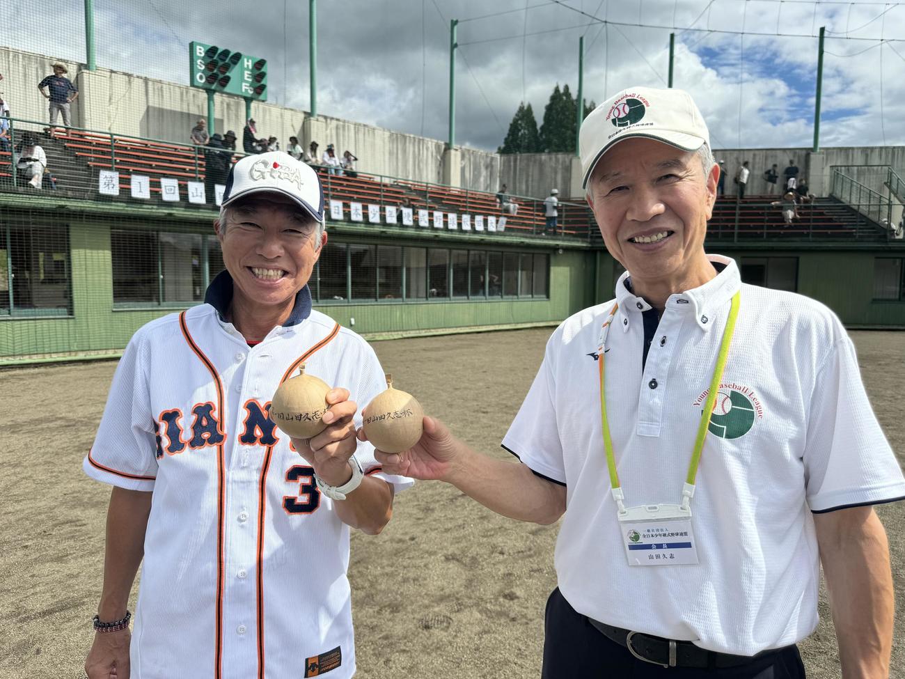 始球式を行った山田久志会長（右）と柳葉敏郎は、大仙市名物の花火玉を手にポーズ