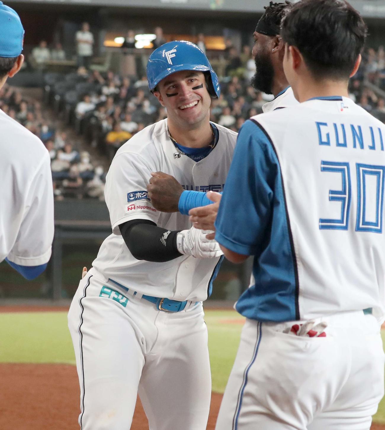 日本ハム対オリックス　5回裏、3点本塁打を放ったマルティネスはナインに出迎えられ笑顔（撮影・黒川智章）