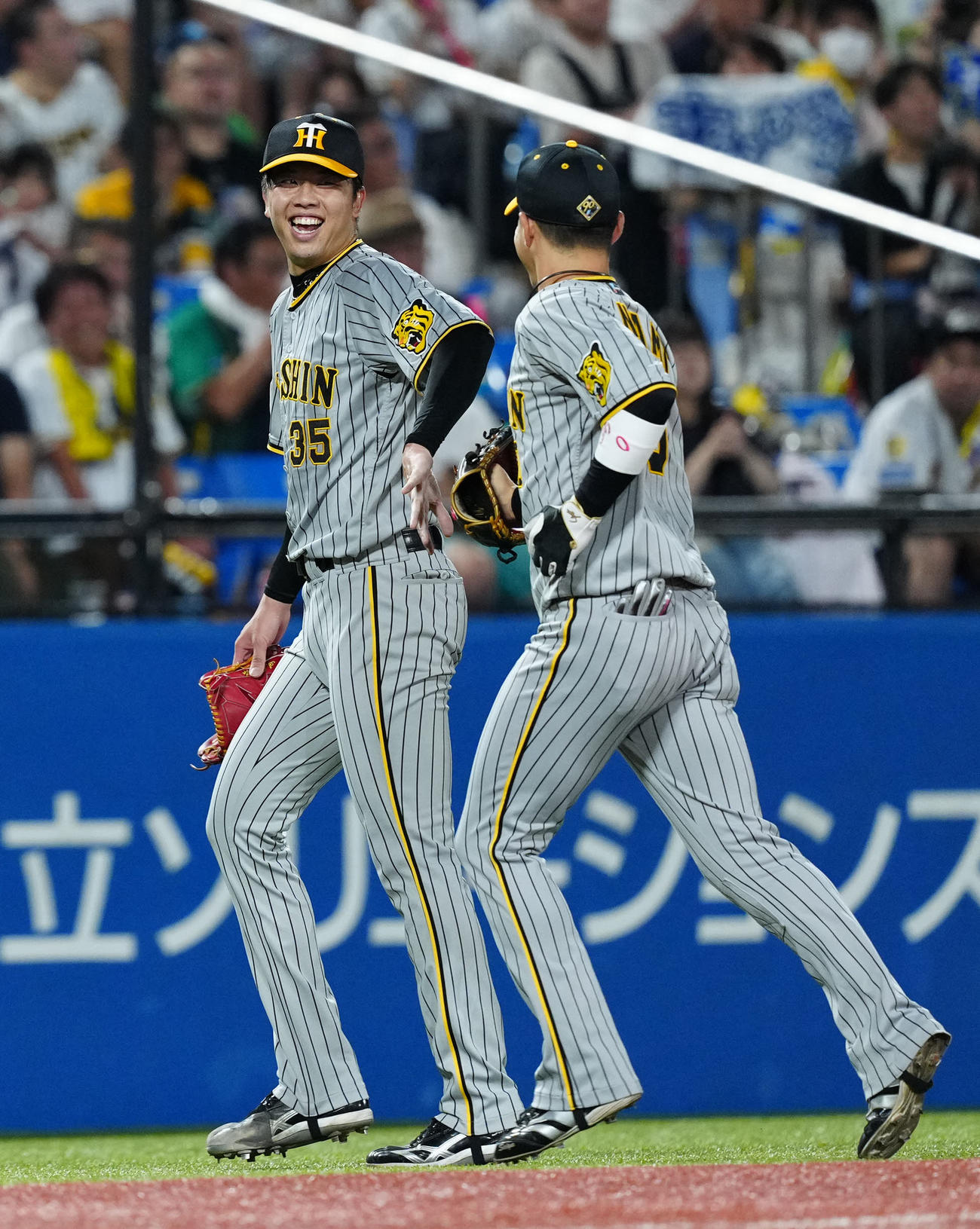 ヤクルト対阪神　4回裏終了後、阪神木浪（右）とタッチを交わす先発の才木（撮影・江口和貴）