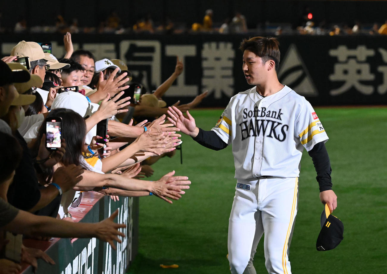 ソフトバンク対西武　ファンとタッチを交わす長谷川（右）（撮影・林敢治）
