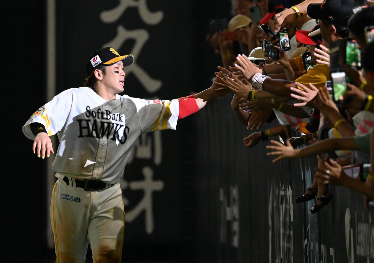 ソフトバンク対西武　ファンとタッチを交わす甲斐（左）（撮影・林敢治）