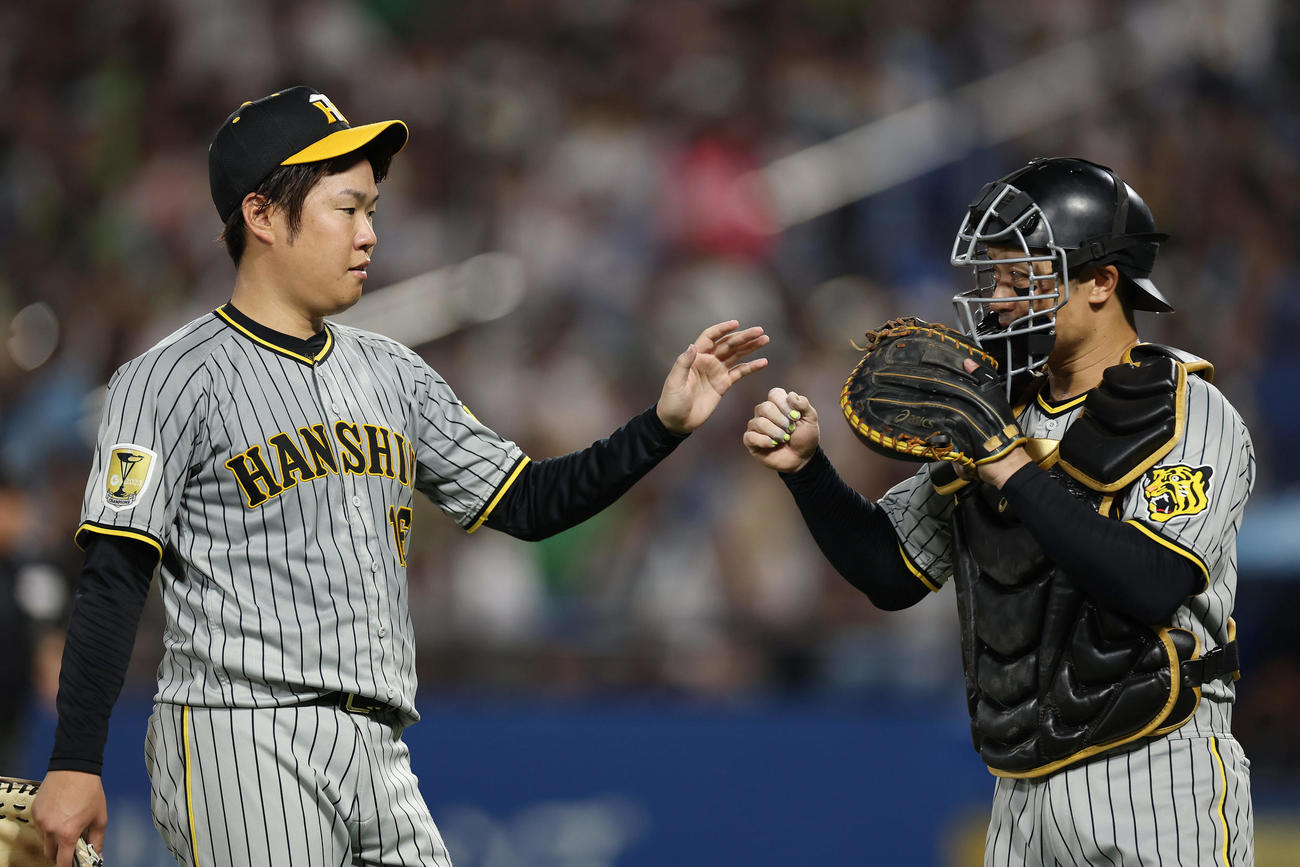 ヤクルト対阪神　5回裏ヤクルト2死一、三塁、沢井を空振り三振に仕留め、坂本（右）とタッチを交わす西勇（撮影・前田充）