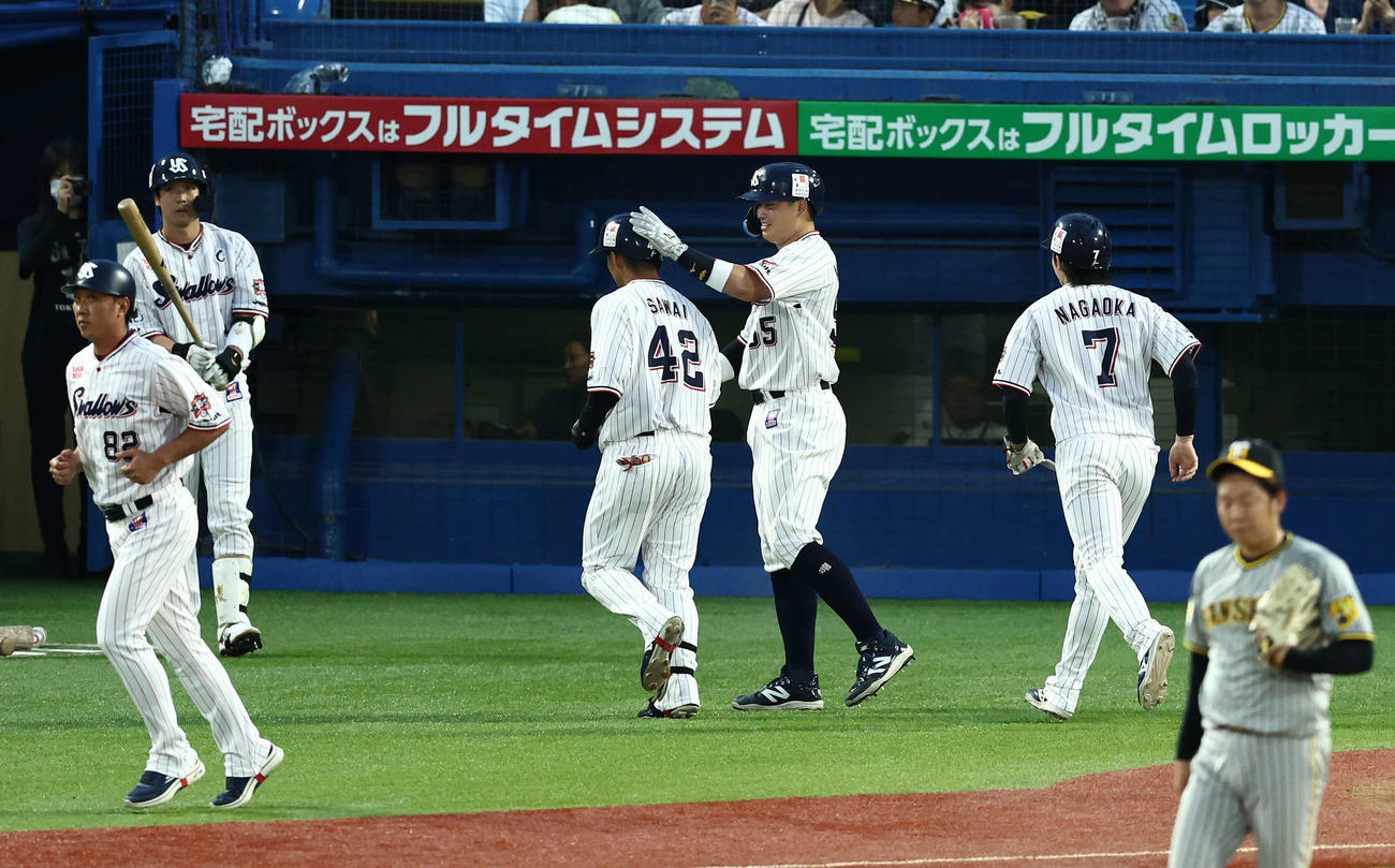 ヤクルト対阪神　3回裏ヤクルト2死一、二塁、右越え3点本塁打で生還し、チームメートに迎えられる沢井（中央）（撮影・河田真司）