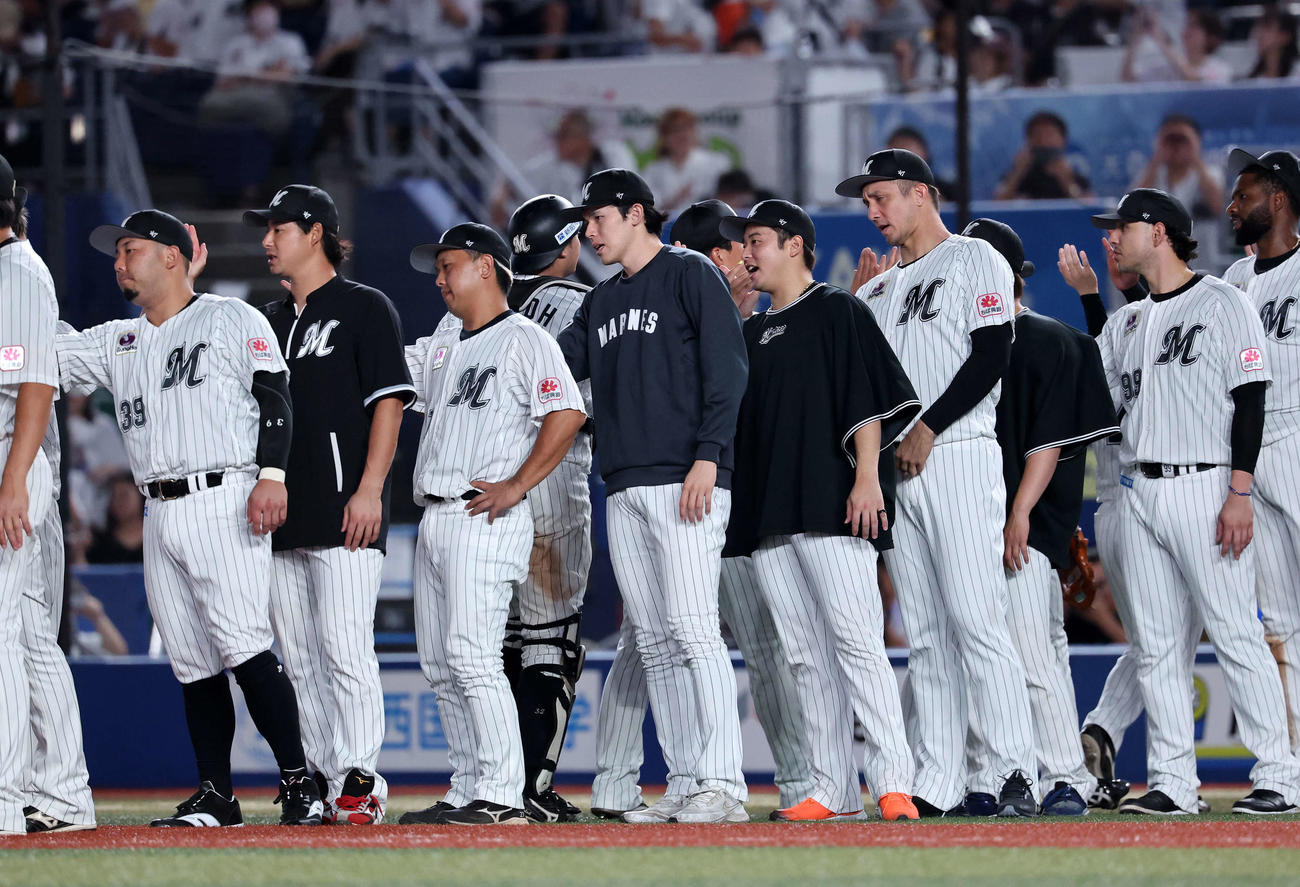 ロッテ対楽天　勝利し選手たちを迎えるロッテ佐々木（中央）（撮影・鈴木正人）