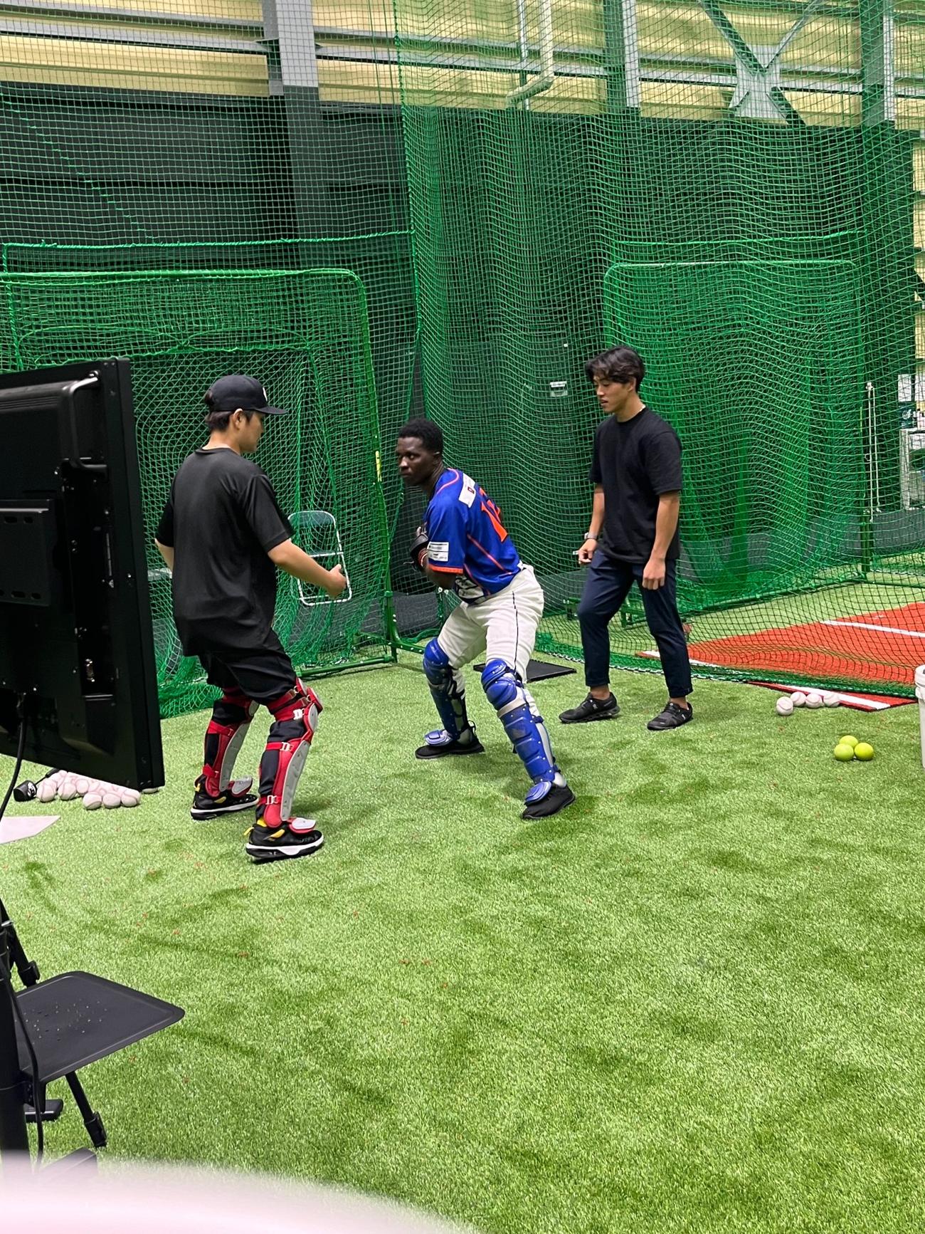 緑川大陸さん（左）から捕球指導を受ける独立リーグ旭川のデニス