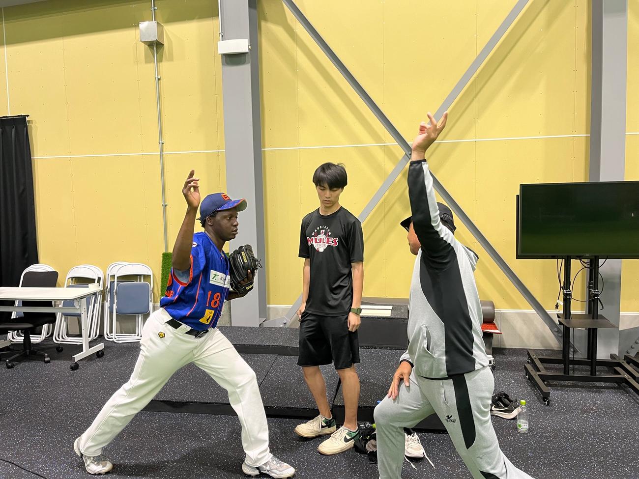 工藤さん（右）から投球指導を受ける旭川ビースターズのアラン