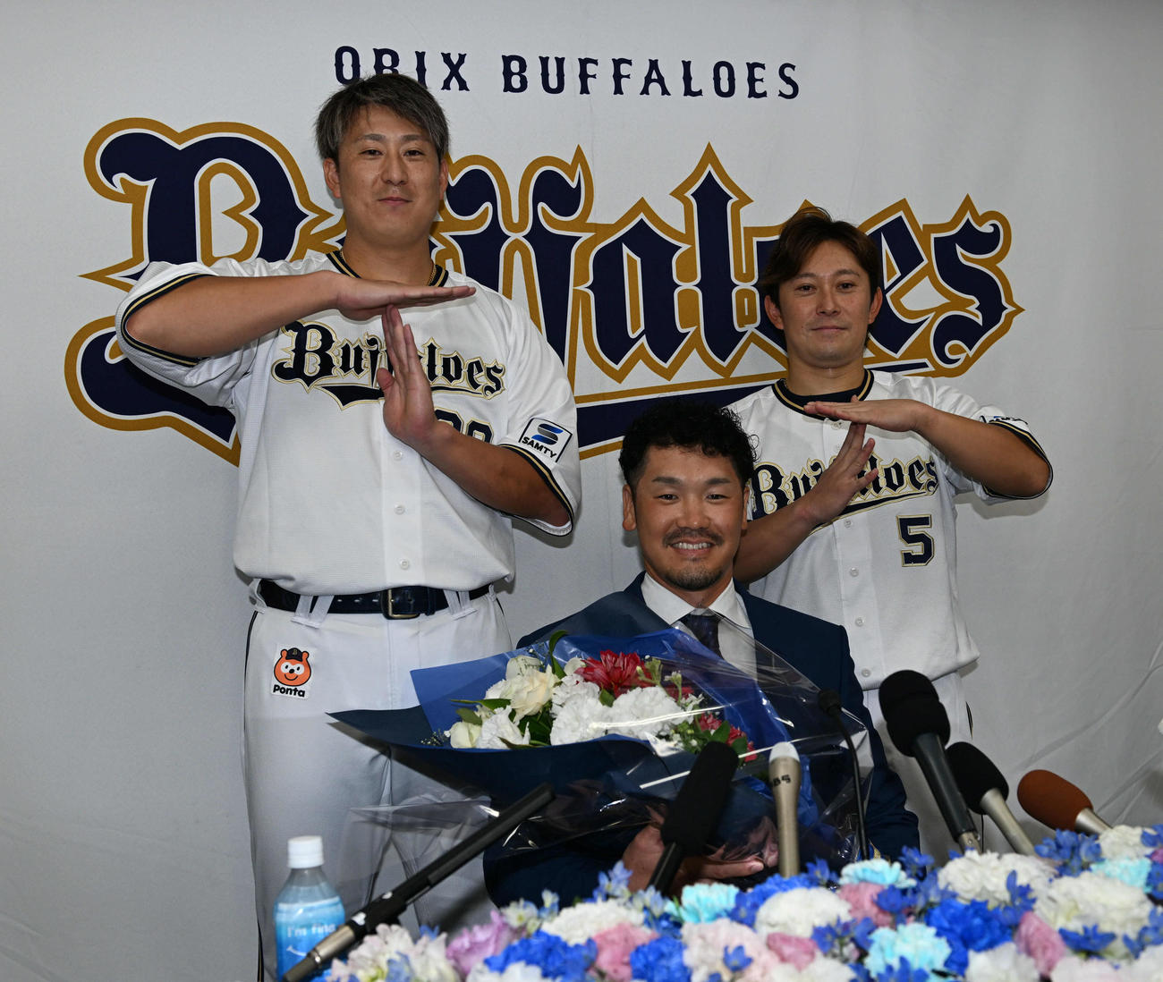 引退会見後、杉本（左）と西野（右）から花束を贈呈されたオリックスTー岡田（撮影・和賀正仁）