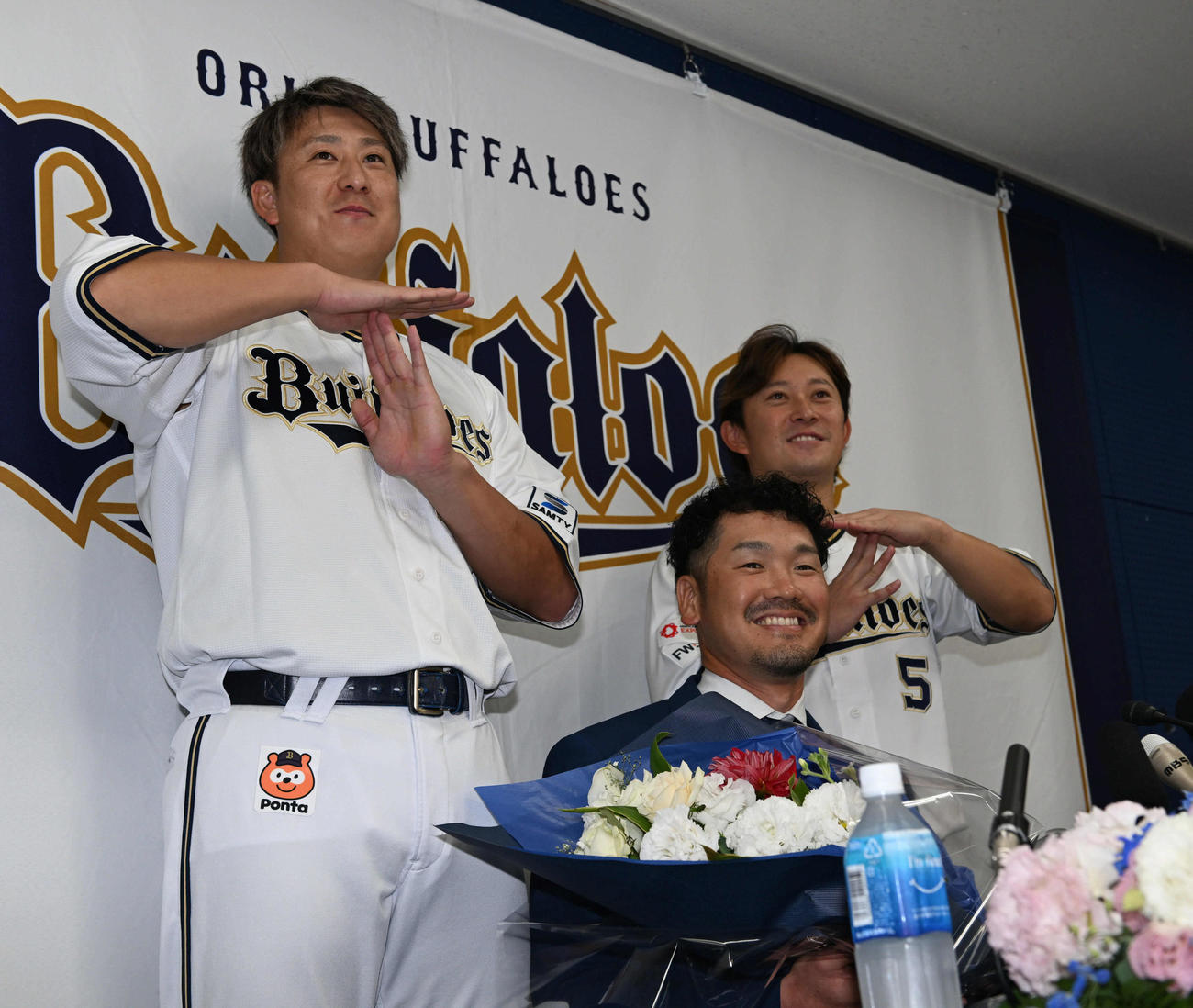 引退会見後、杉本（左）と西野（右）から花束を贈呈されたオリックスTー岡田（撮影・和賀正仁）