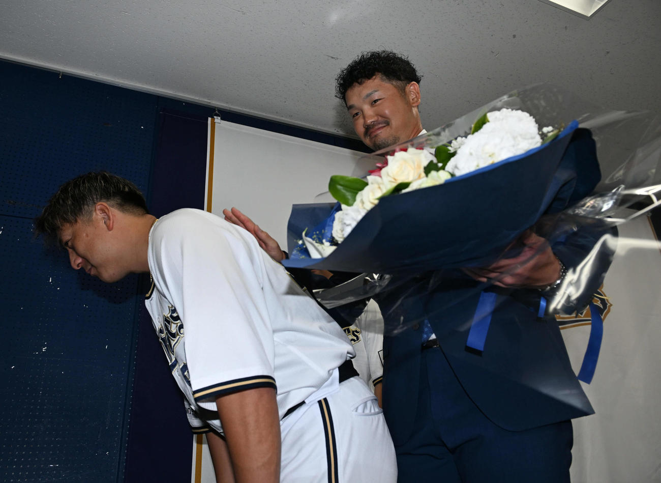 引退会見後、杉本（左）の背中を叩き残り試合に気合を入れるオリックスTー岡田（撮影・和賀正仁）