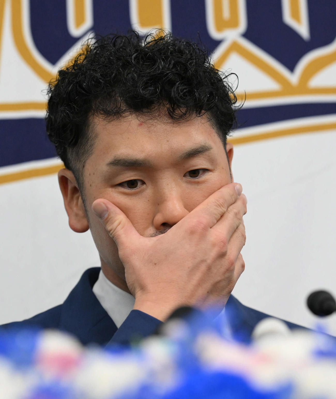 引退会見を行い、ほおに手をやるオリックスTー岡田（（撮影・和賀正仁）