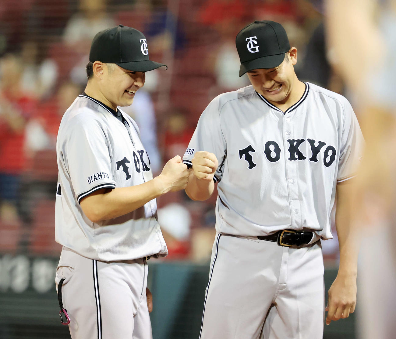 広島対巨人　14勝目を挙げた巨人菅野（右）は杉内投手チーフコーチと笑顔でグータッチ（撮影・浅見桂子）