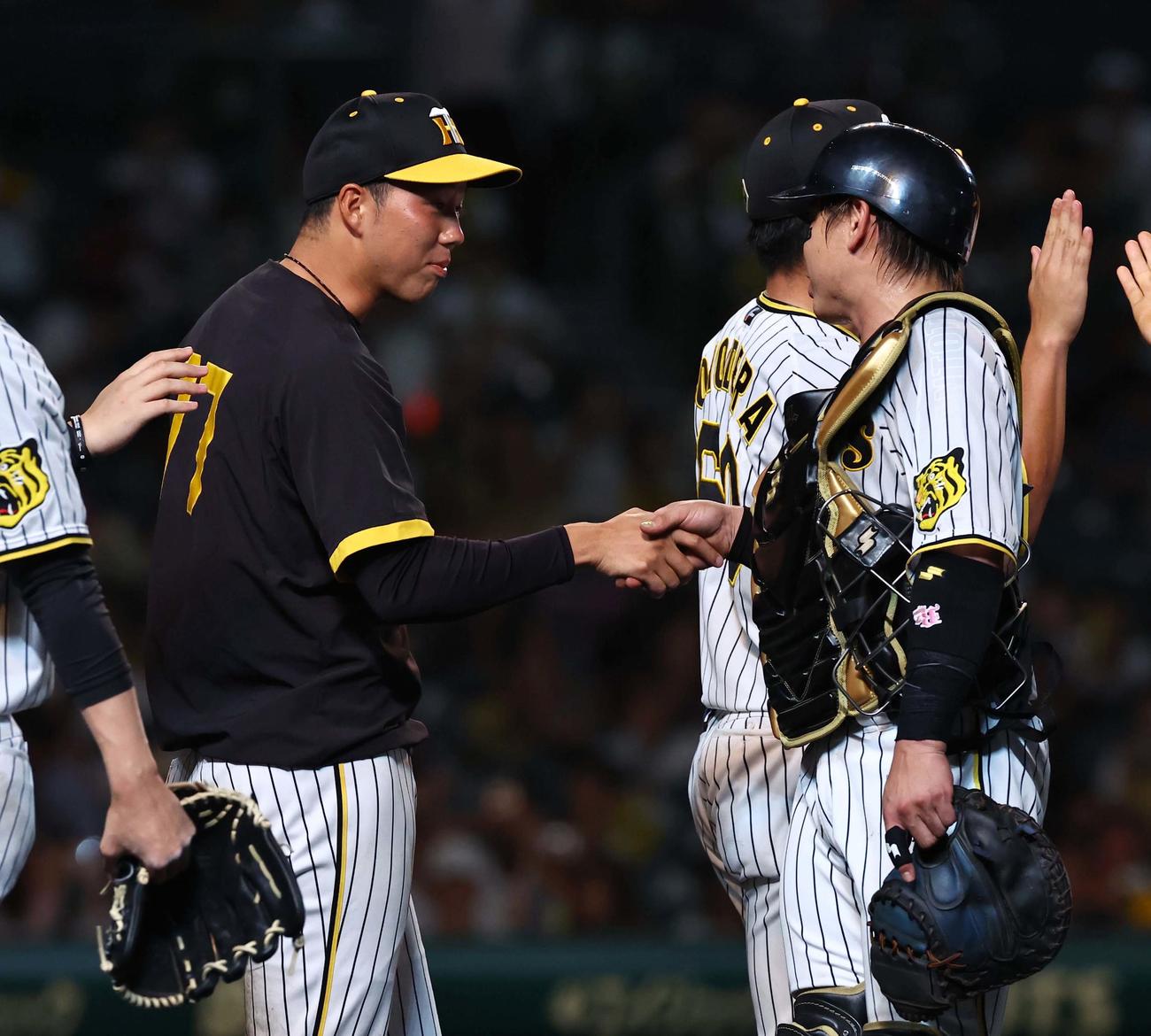 阪神対DeNA 2勝目をあげた青柳（左）は梅野と握手を交わす（撮影・上田博志）