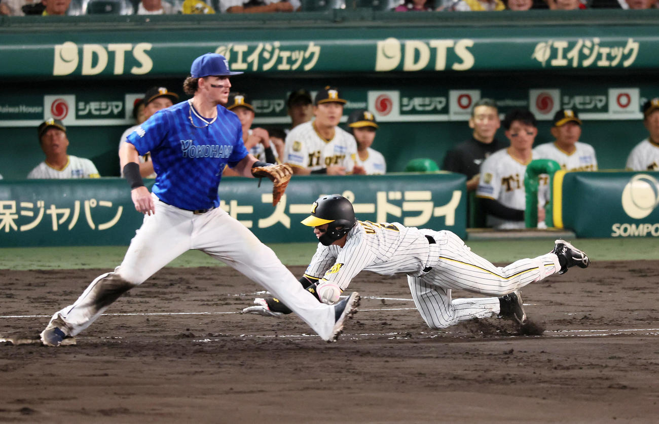 阪神対DeNA 6回裏阪神無死、梅野は投手内野安打を放ち一塁にヘッドスライディング。一塁手オースティン（撮影・加藤哉）