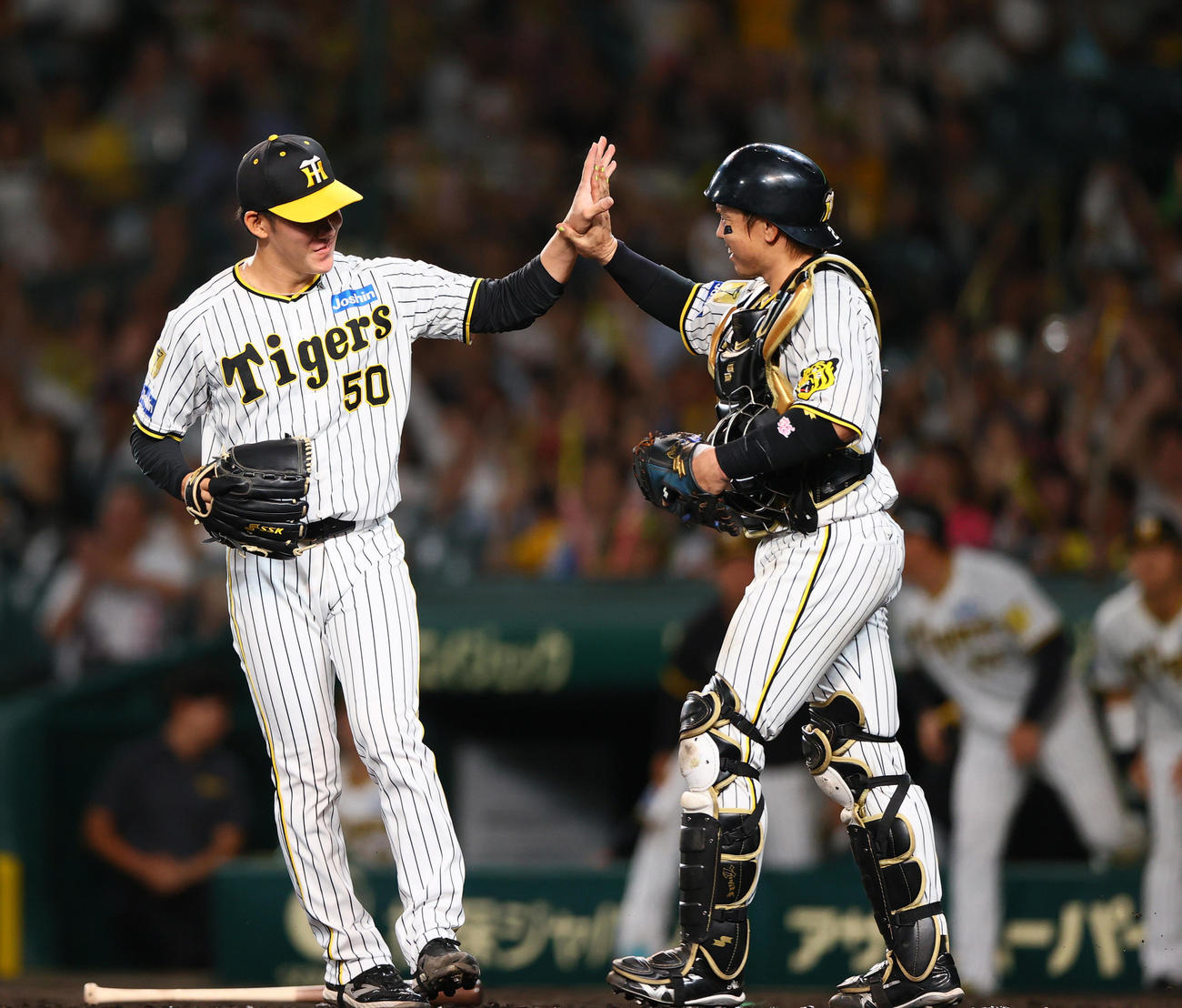 阪神対DeNA　試合を締めた富田（左）は捕手梅野とタッチをかわす（撮影・上山淳一）