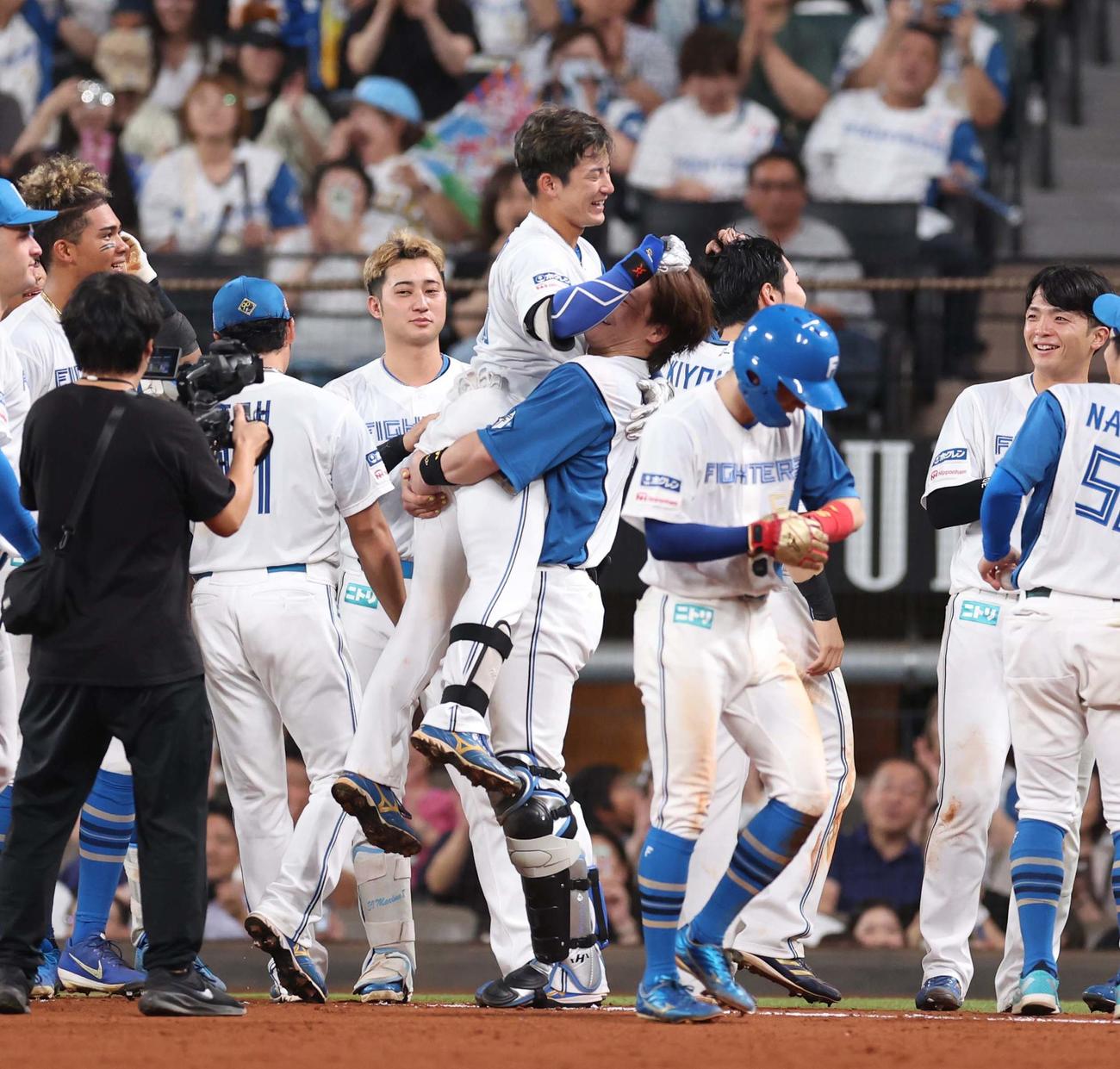 日本ハム対西武　9回裏、サヨナラ打を放った水野は伏見に抱きかかえられ笑顔（撮影・黒川智章）