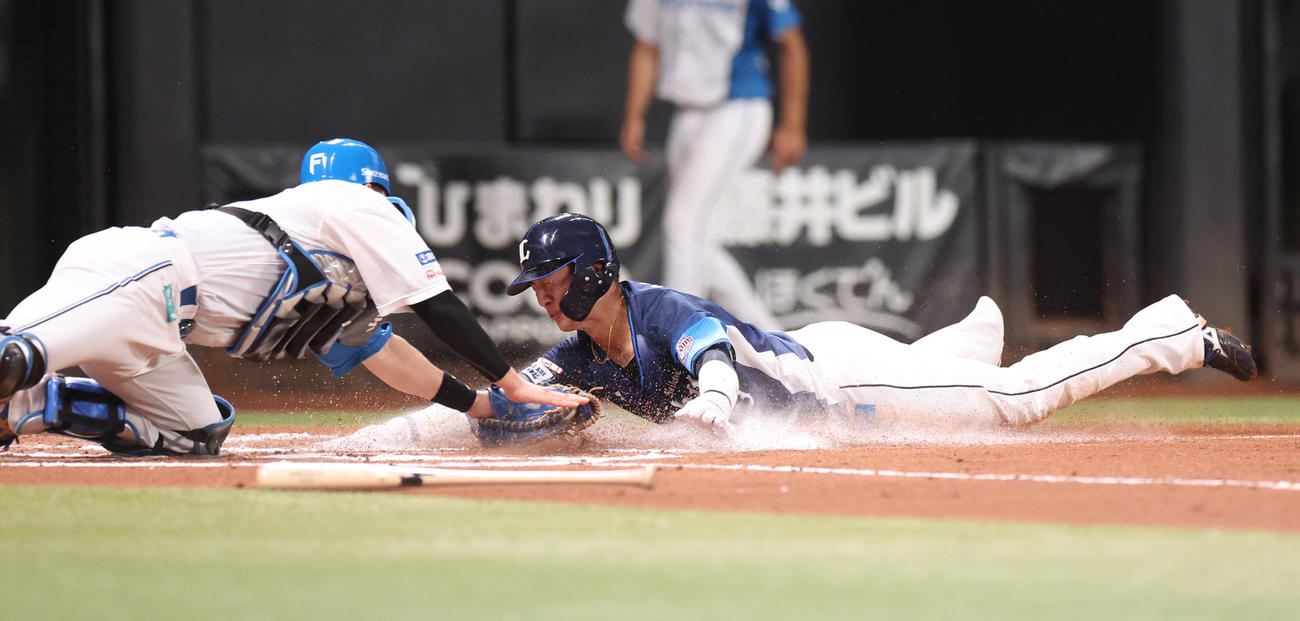 日本ハム対西武　6回表西武2死二塁、西川の右前打で生還を試みる二塁走者の長谷川は本塁でタッチアウトになる。捕手伏見（撮影・佐藤翔太）