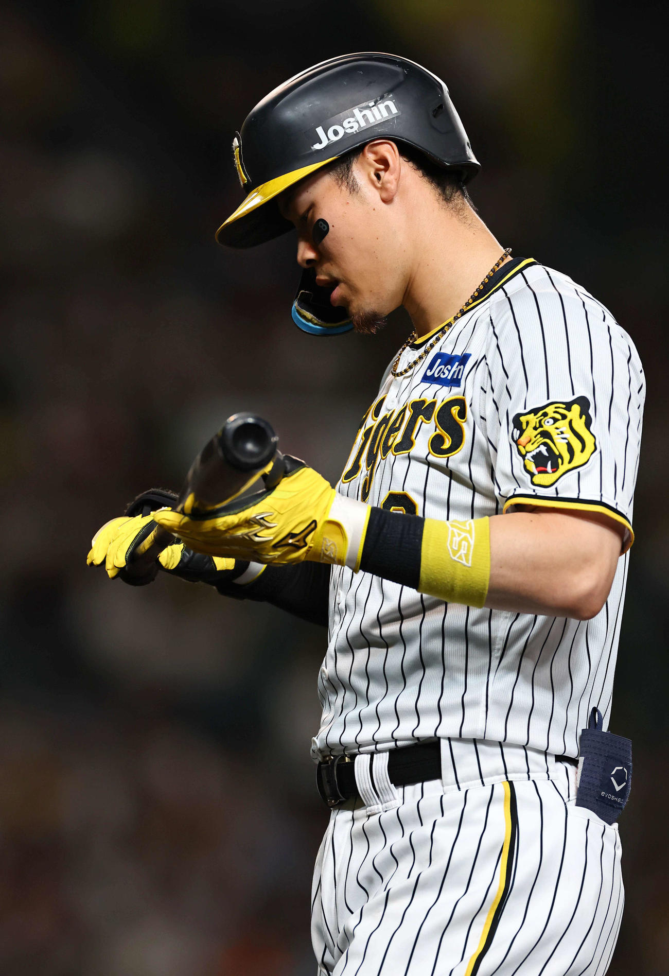 阪神対DeNA 8回裏阪神1死二塁、中飛に倒れた佐藤輝はバットを見つめながらベンチに引き揚げる（撮影・上田博志）