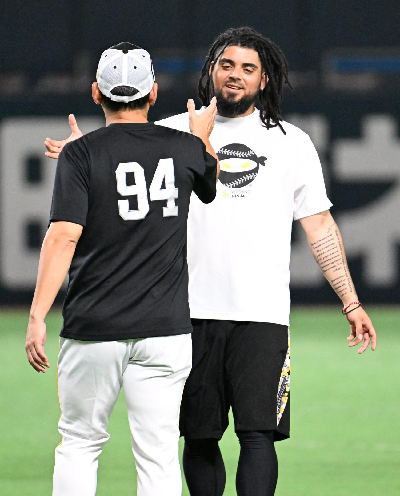 9日、握手を交わすソフトバンク倉野信次コーチ（左）とロベルト・オスナ