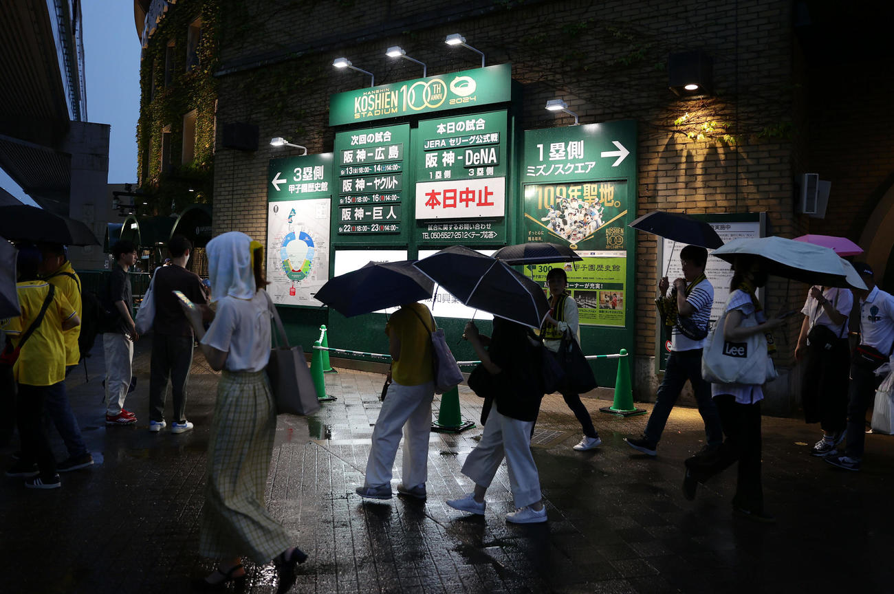 阪神対DeNA　試合前の豪雨で試合が中止となり、帰路につく観客ら（撮影・前田充）