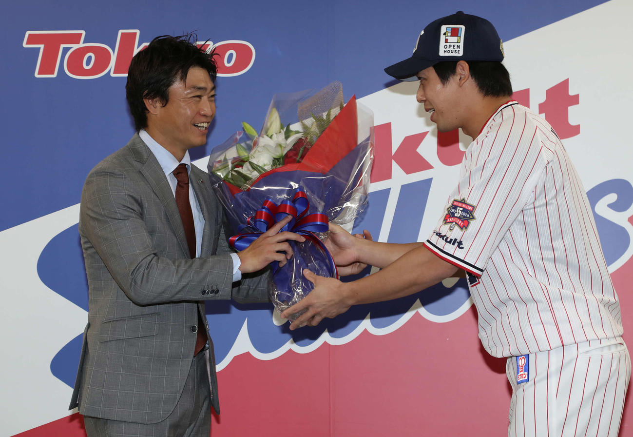 山田（右）から花束を受け取る青木（撮影・丹羽敏通）