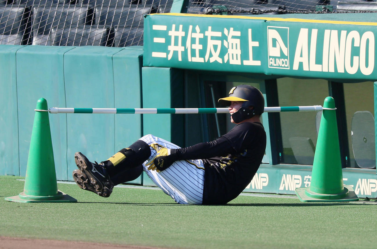 阪神対広島　打撃練習中に自打球を足に当て痛さからそのまま三塁ベンチ前まで移動して転倒する森下（撮影・加藤哉）