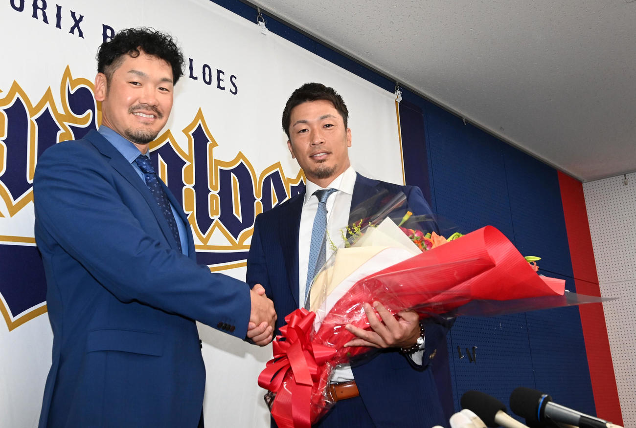 先日、引退会見を行ったT－岡田（左）から花束を受け取るオリックス安達（撮影・前岡正明）