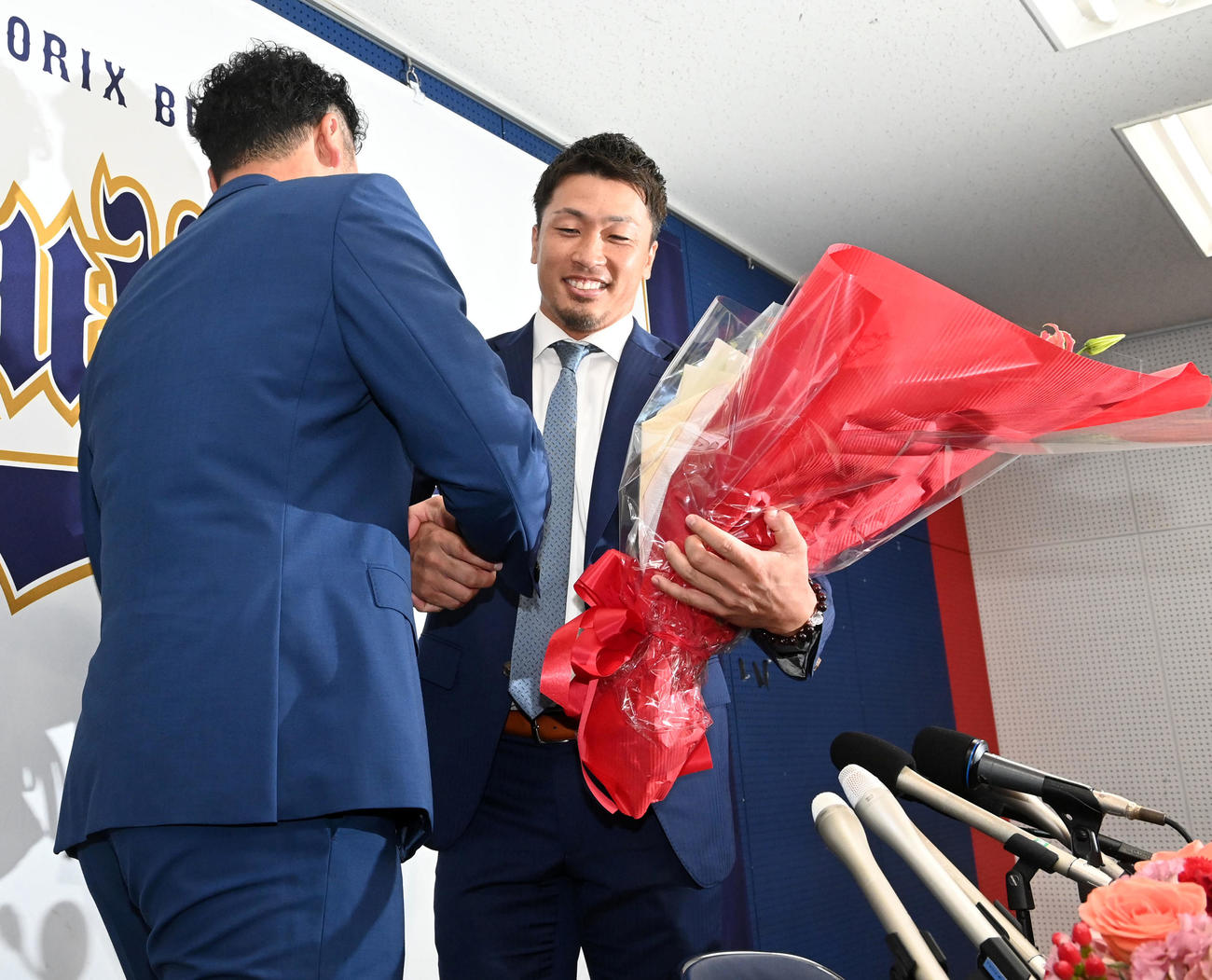 先日、引退会見を行ったT－岡田（左）から花束を受け取るオリックス安達（撮影・前岡正明）