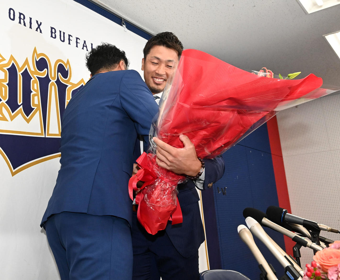 先日、引退会見を行ったT－岡田（左）から花束を受け取るオリックス安達（撮影・前岡正明）