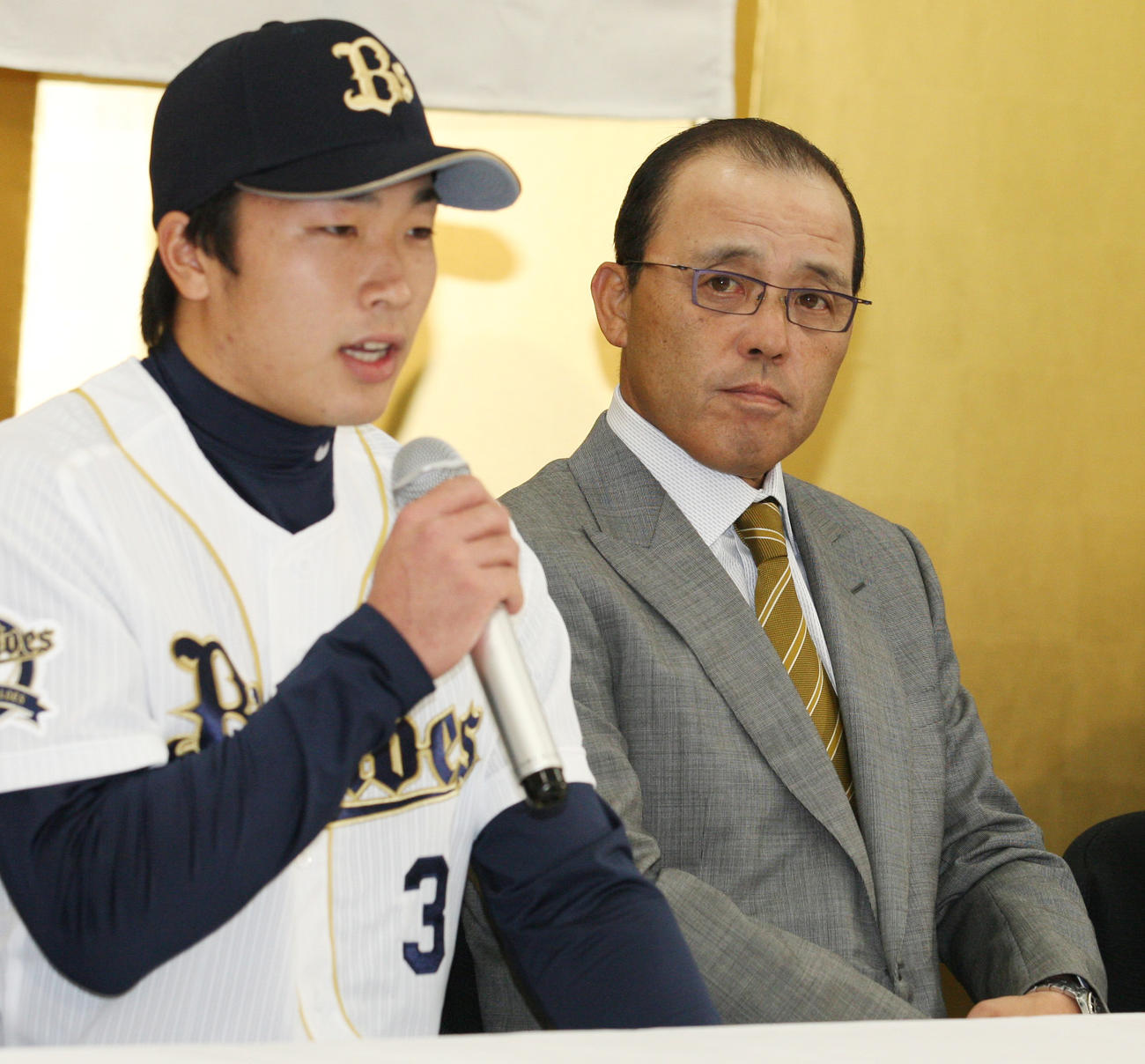 11年12月7日、オリックス新入団発表　新入団選手発表会見で1位の安達（左）のあいさつに耳を傾ける岡田監督
