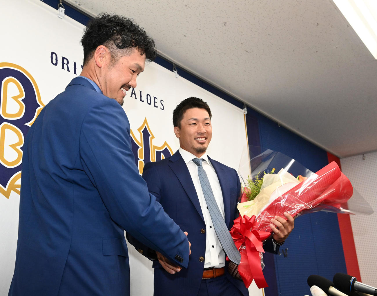 先日、引退会見を行ったT－岡田（左）から花束を受け取るオリックス安達（撮影・前岡正明）