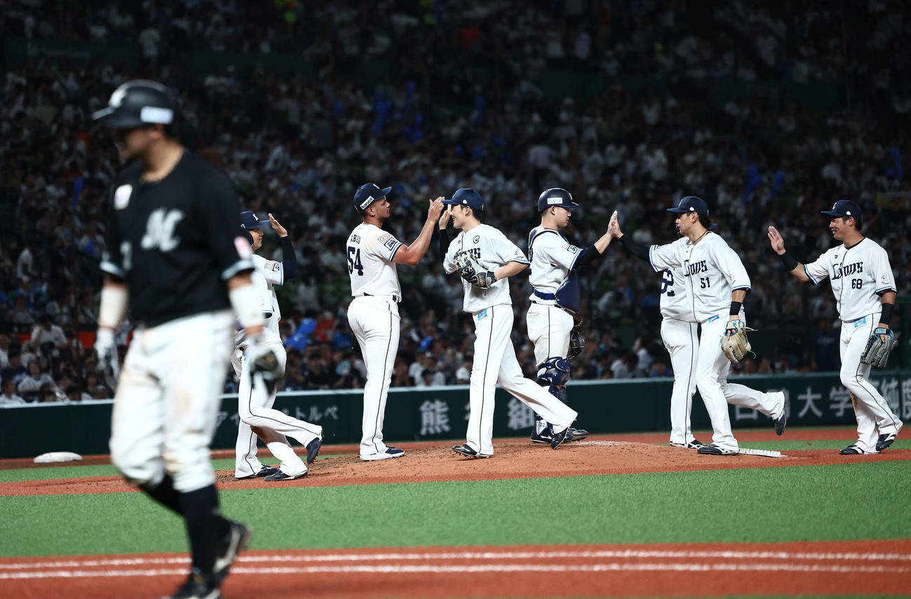 西武対ロッテ　ロッテに勝利し、マウンドでタッチを交わす西武ナイン（撮影・河田真司）