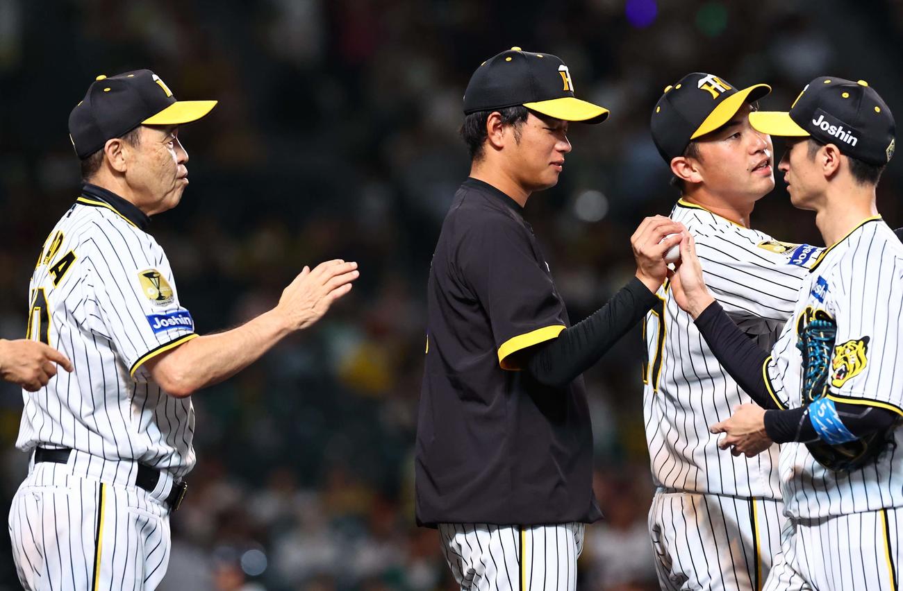 阪神対広島　4勝目を上げた高橋（中央）は近本（右）から勝利球を受け取る。左は岡田監督（撮影・上田博志）