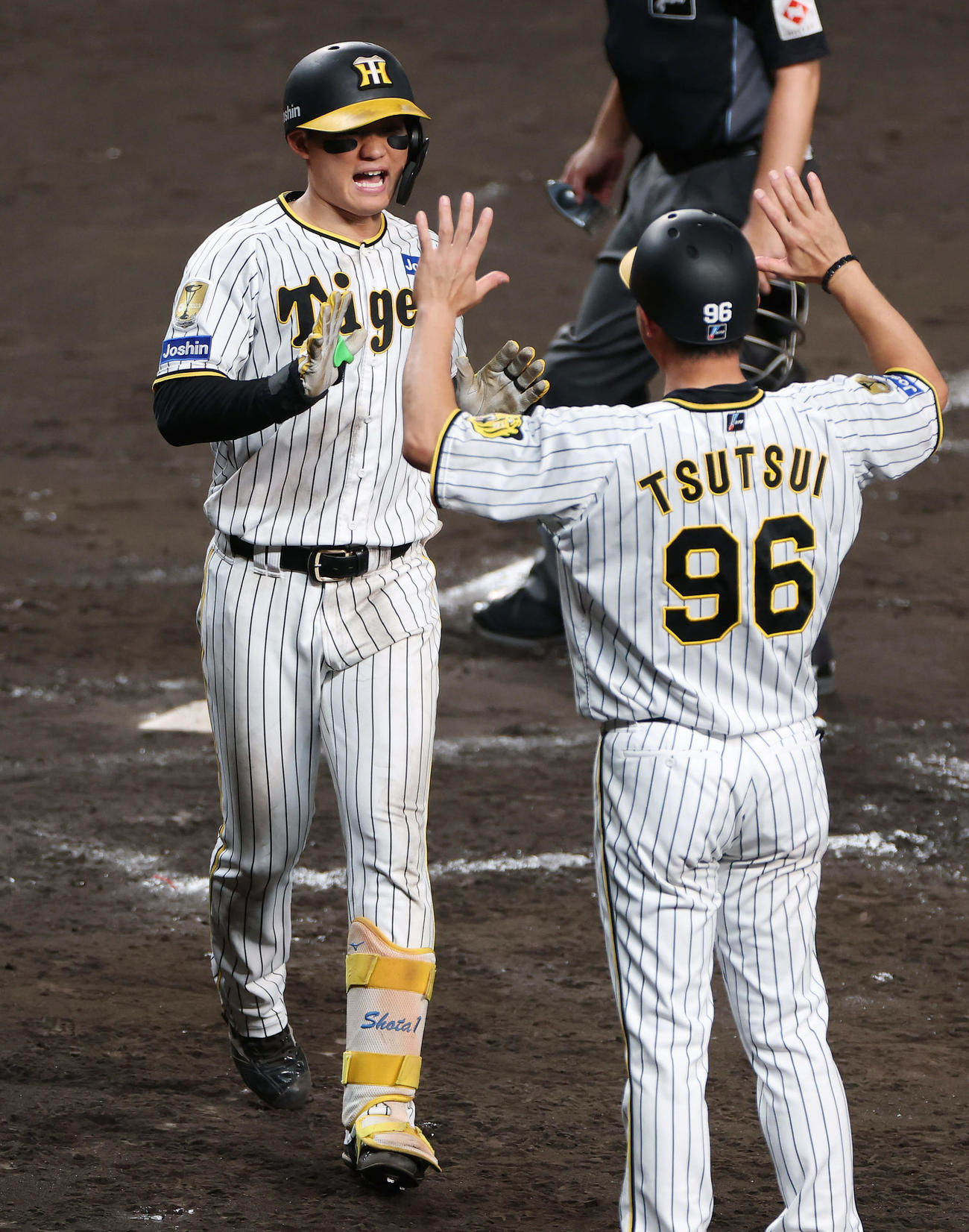 阪神対広島　7回裏阪神2死、左越え本塁打を放ち、筒井コーチ（右）とタッチを交わす森下（撮影・前田充）