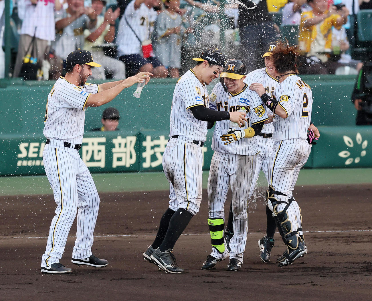 阪神対広島　9回裏阪神2死二、三塁、中野のサヨナラ中適時打にウオーターシャワーをかけるゲラ（左）。左から2人目は佐藤輝（撮影・加藤哉）