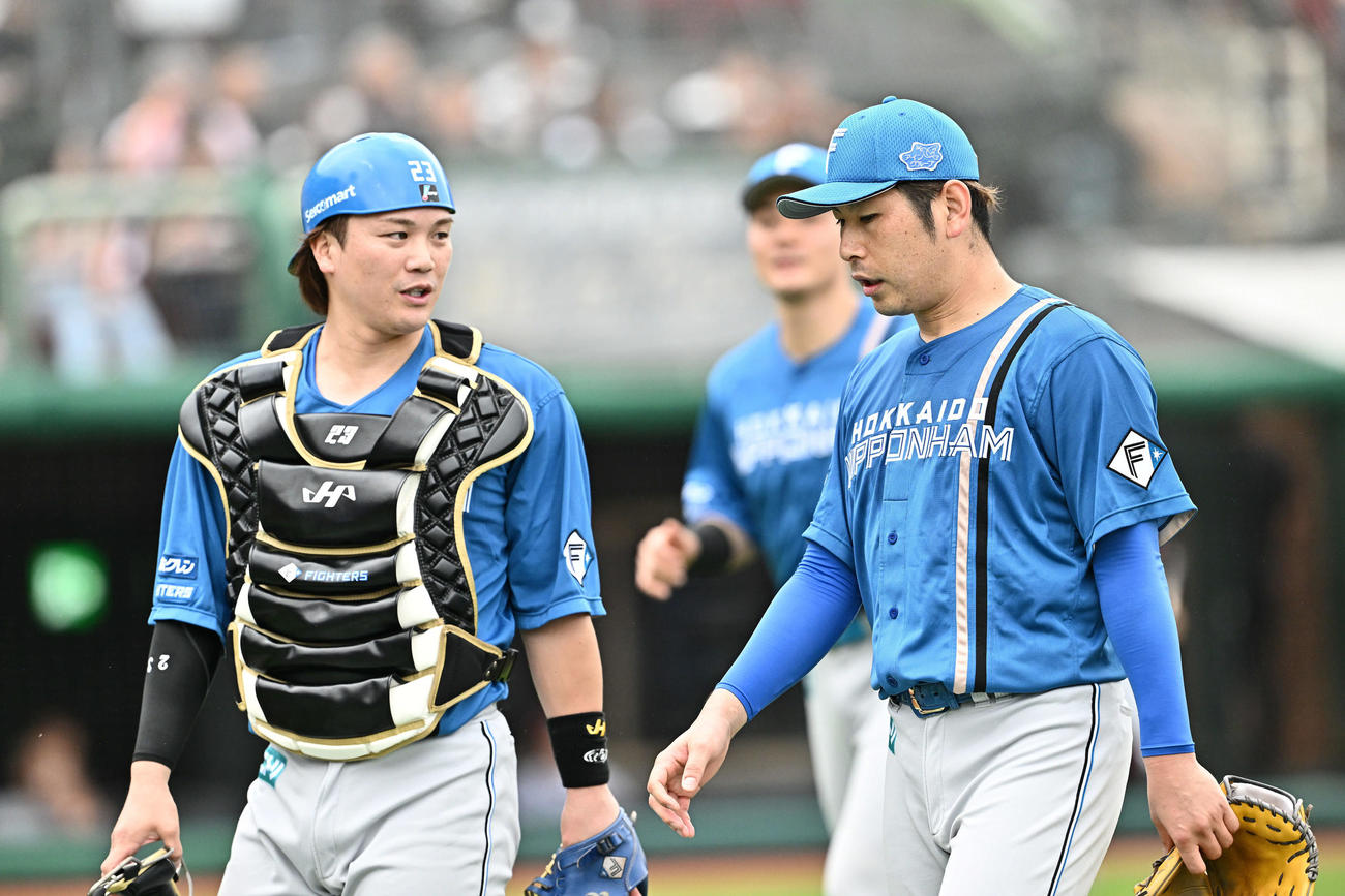 楽天対日本ハム　1回裏を投げ終え引き揚げる日本ハム先発の加藤貴（右）と伏見（撮影・滝沢徹郎）