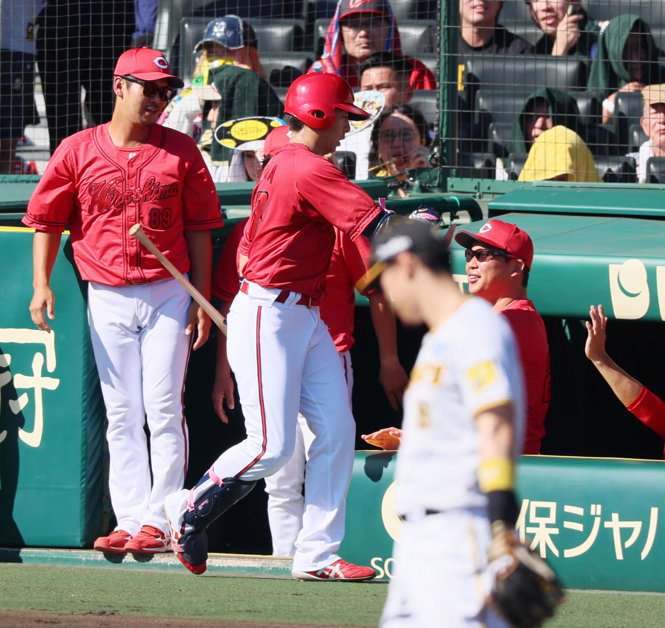 阪神対広島　4回表広島1死三塁、新井監督（右）は先制中犠飛を打った野間とタッチ（撮影・加藤哉）