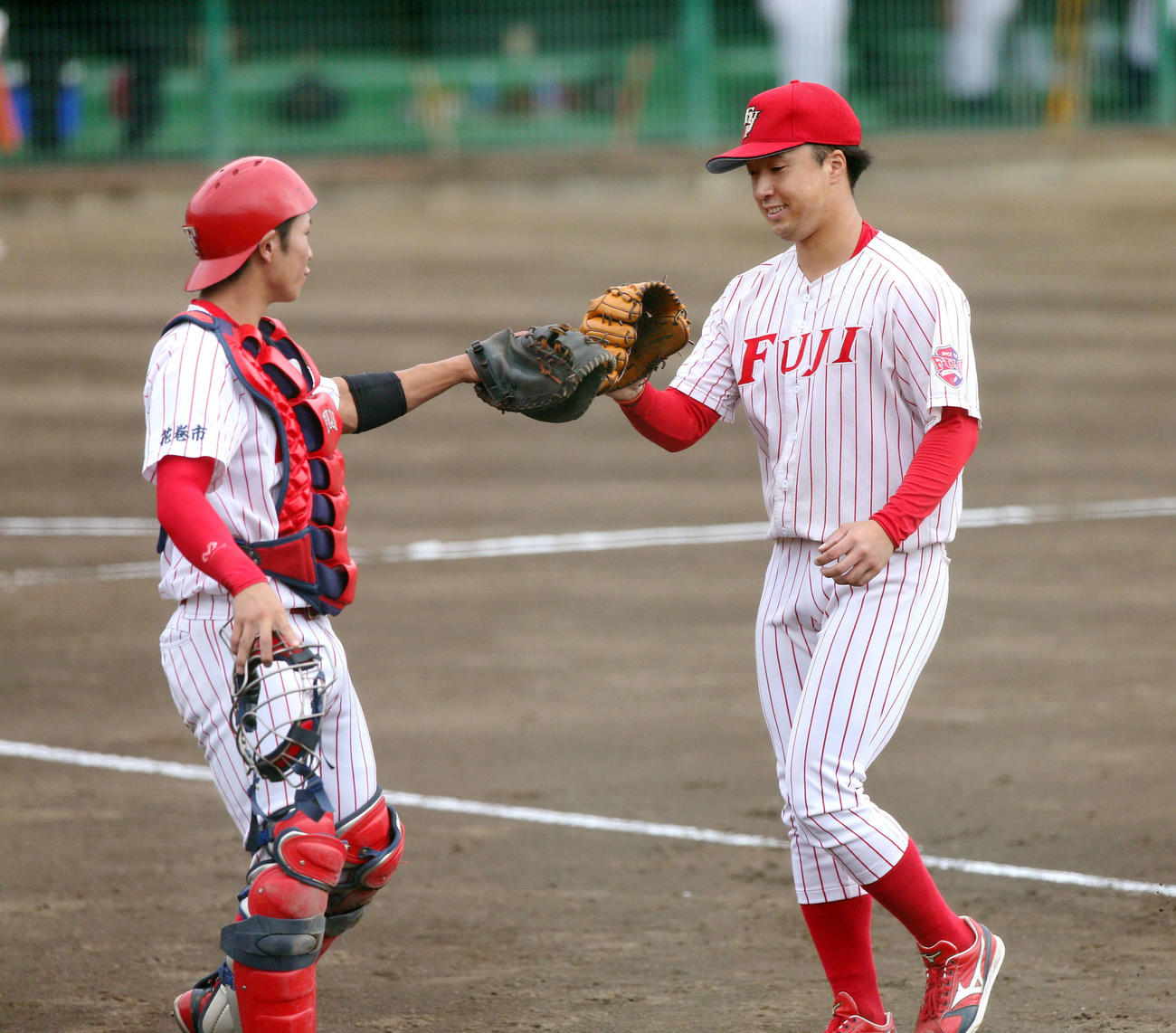 八戸学院大対富士大　初回から3イニング連続3者凡退に抑え、グラブタッチをかわす富士大・佐藤（右）と坂本（撮影・木村有優）