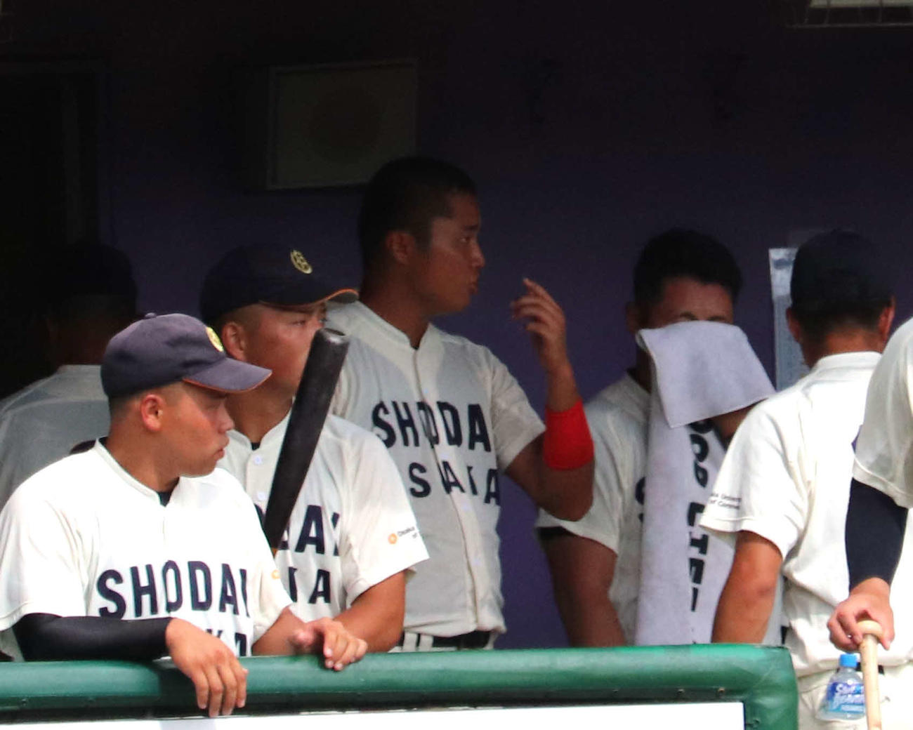 龍谷大との1回戦　34度の猛暑の中、後輩の大商大・真鍋（中央）の隣でタオルを手に大粒の汗を拭う渡部（撮影・中島麗）