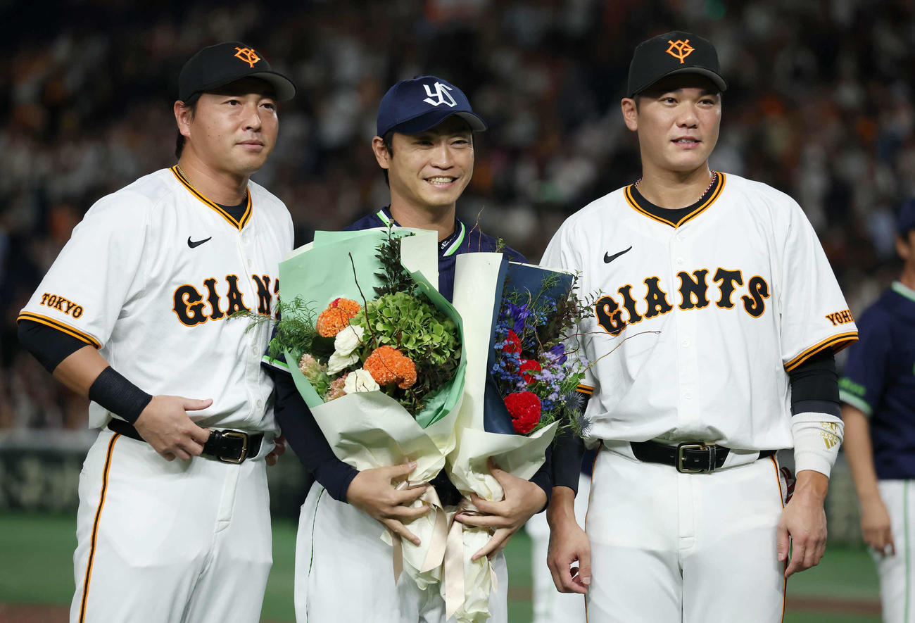 巨人対ヤクルト　巨人長野（左）坂本勇（右）から花束を受け取ったヤクルト青木（撮影・丹羽敏通）