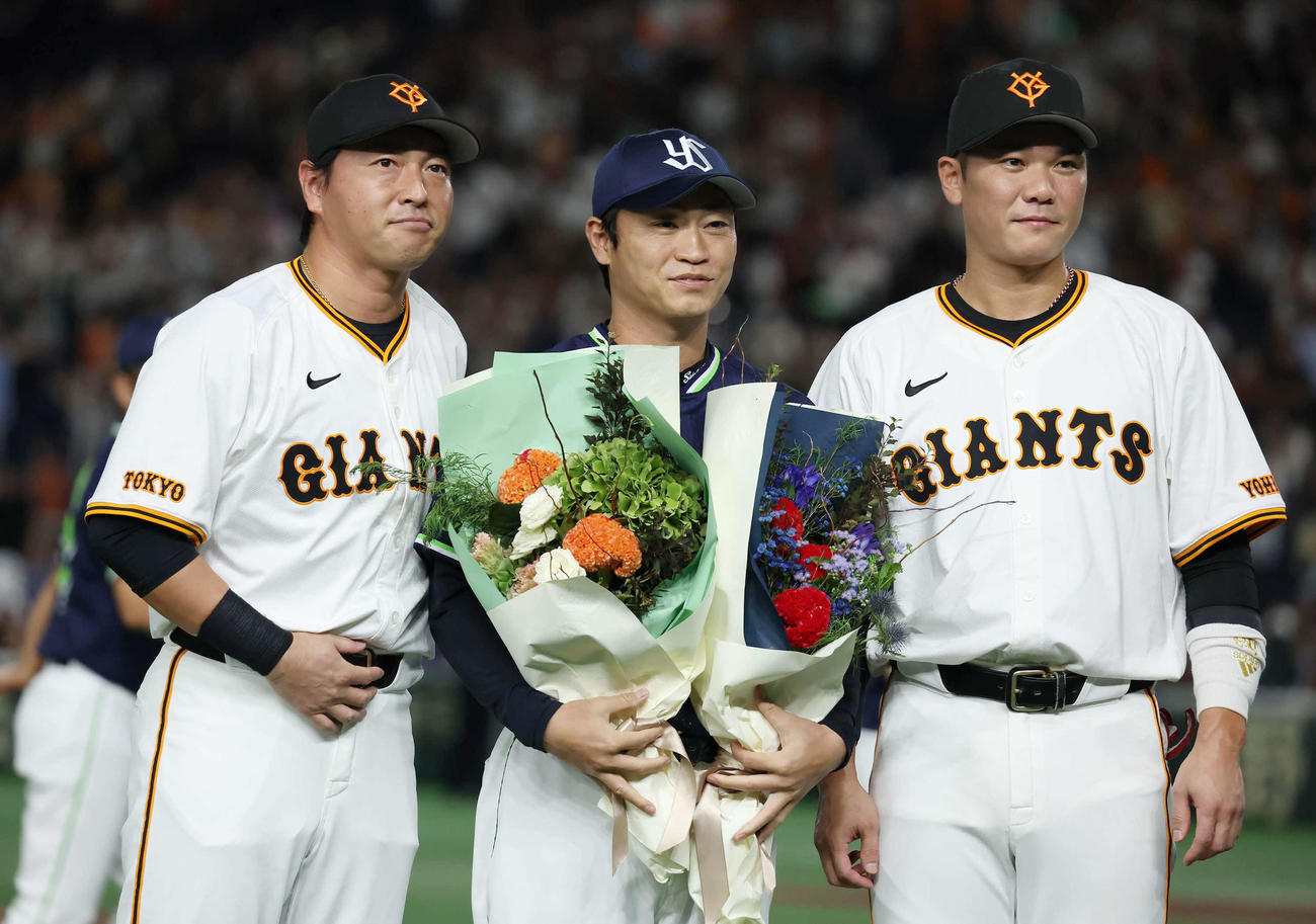 巨人対ヤクルト　巨人の長野（左）、坂本勇（右）両選手から花束を受け取ったヤクルト青木（撮影・丹羽敏通）