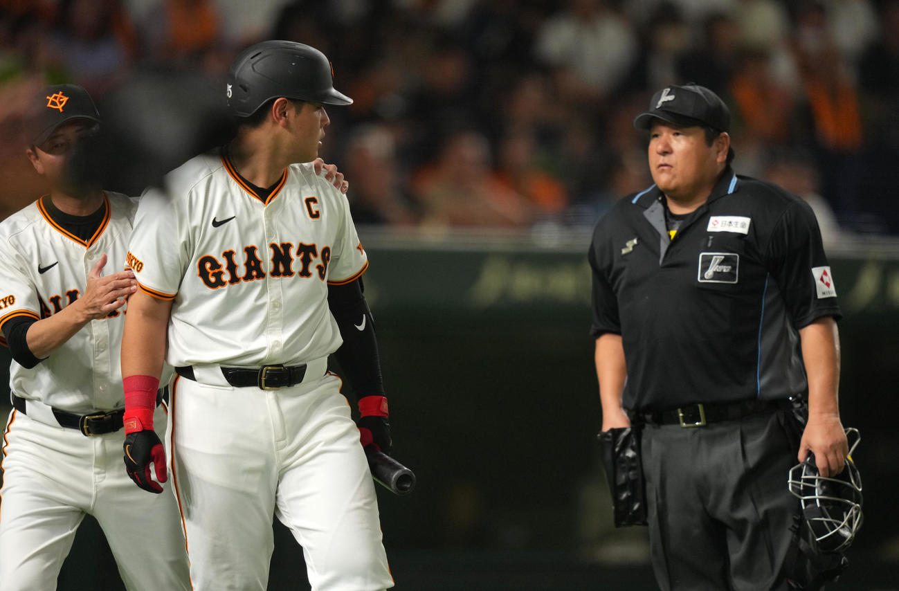 巨人対ヤクルト　7回裏巨人2死一、二塁、見逃し三振に倒れた岡本和は敷田球審（右）とにらみ合う（撮影・横山健太）