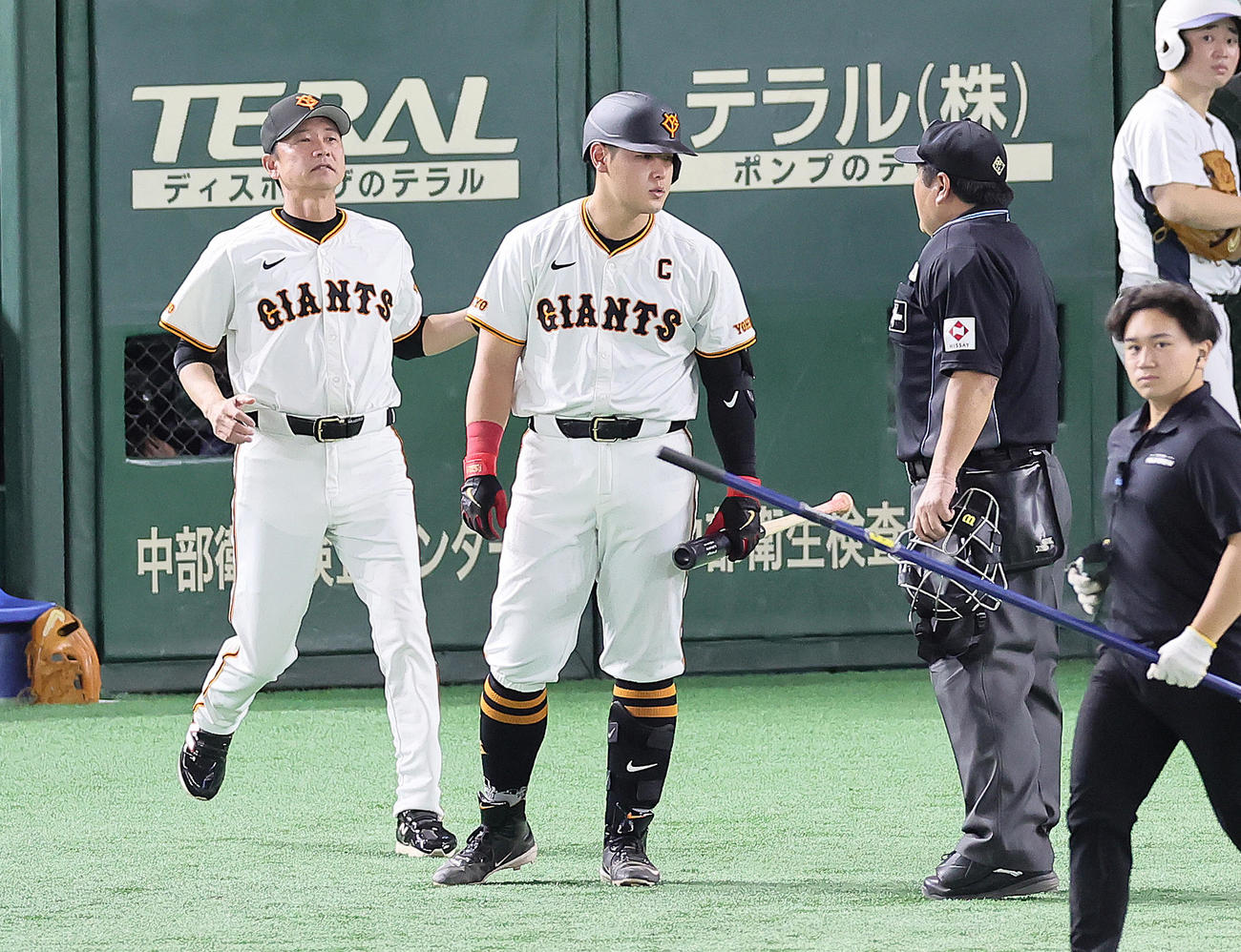 巨人対ヤクルト　7回裏巨人2死一、二塁、見逃し三振に倒れた岡本和（中央）は球審に詰め寄るも二岡ヘッドコーチ（左）に制止される（撮影・足立雅史）