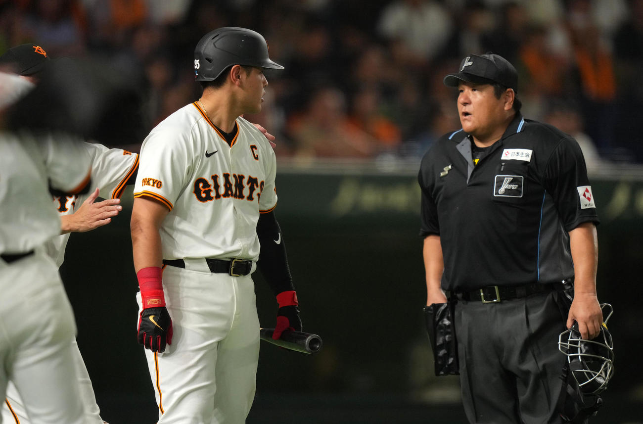 巨人対ヤクルト　7回裏巨人2死一、二塁、見逃し三振に倒れた岡本和は敷田球審（右）とにらみ合う（撮影・横山健太）