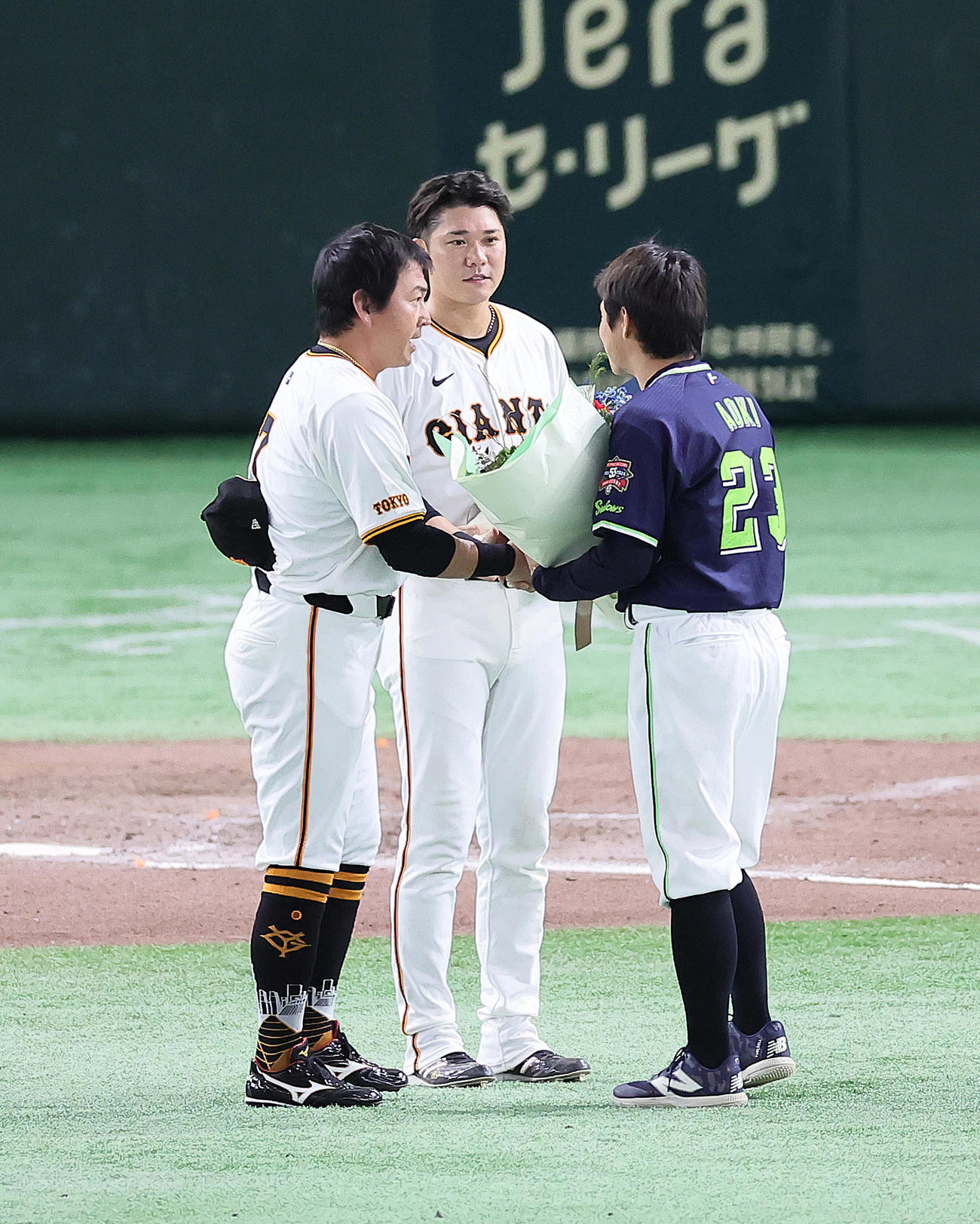 巨人対ヤクルト　引退を表明したヤクルト青木（右）は東京ドームでの巨人最終戦を終え、長野（左）、坂本から花束を受け取る（撮影・足立雅史）