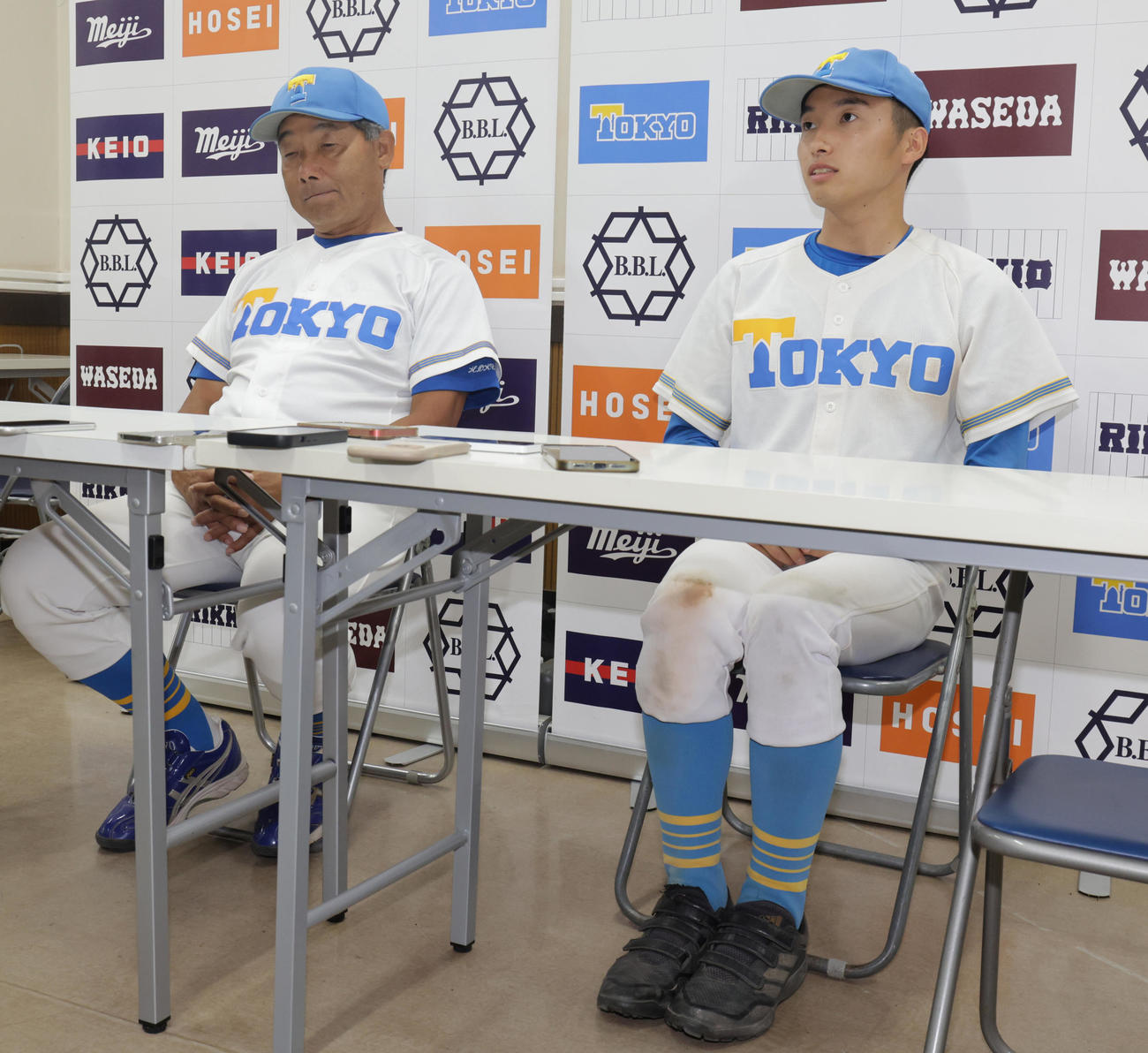 東大対早大　試合後に、足をきちんとそろえて会見する東大先発の渡辺。左は大久保監督（撮影・野上伸悟）