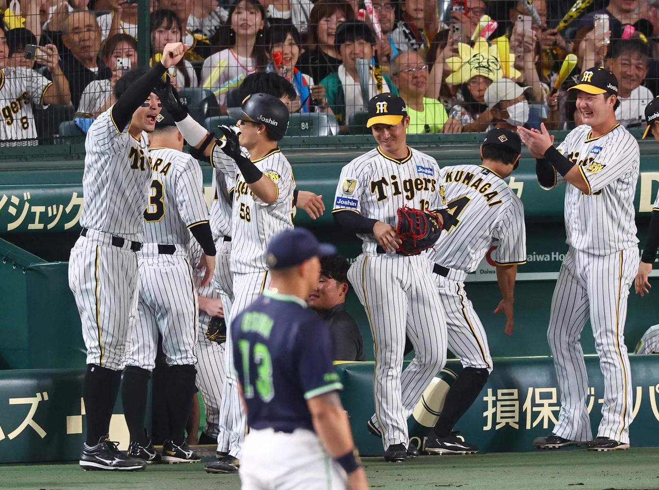 阪神対ヤクルト　2回裏阪神1死、右越えに勝ち越しソロ本塁打を放った前川（右から3人目）は佐藤輝（左）と喜び合う（撮影・上田博志）